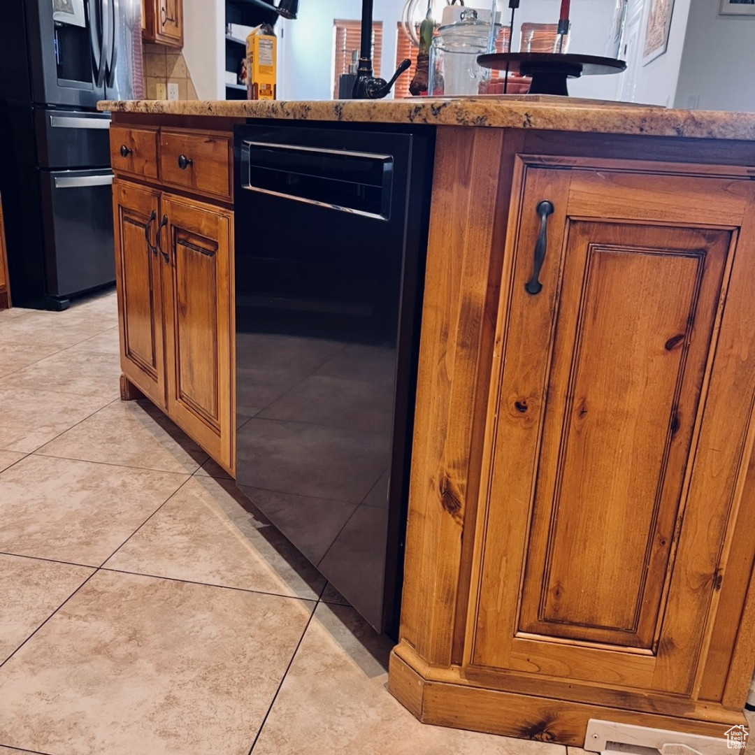 Kitchen featuring light tile patterned flooring, wine cooler, and refrigerator with ice dispenser