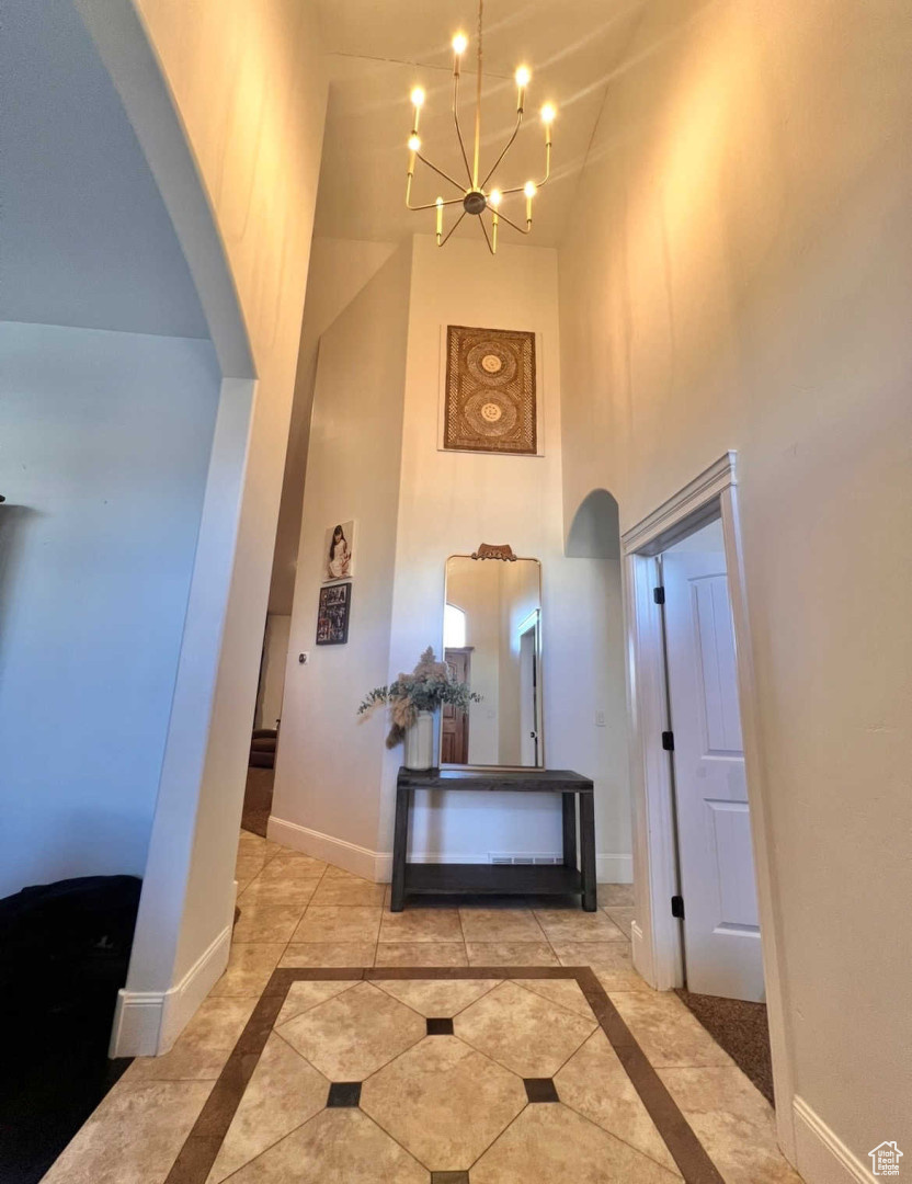 Hall with a towering ceiling and a chandelier