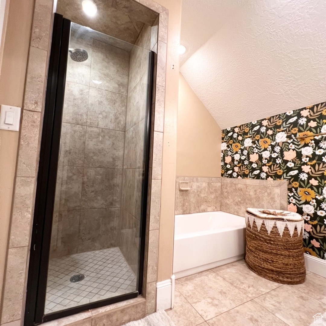 Bathroom with tile patterned floors, independent shower and bath, and a textured ceiling