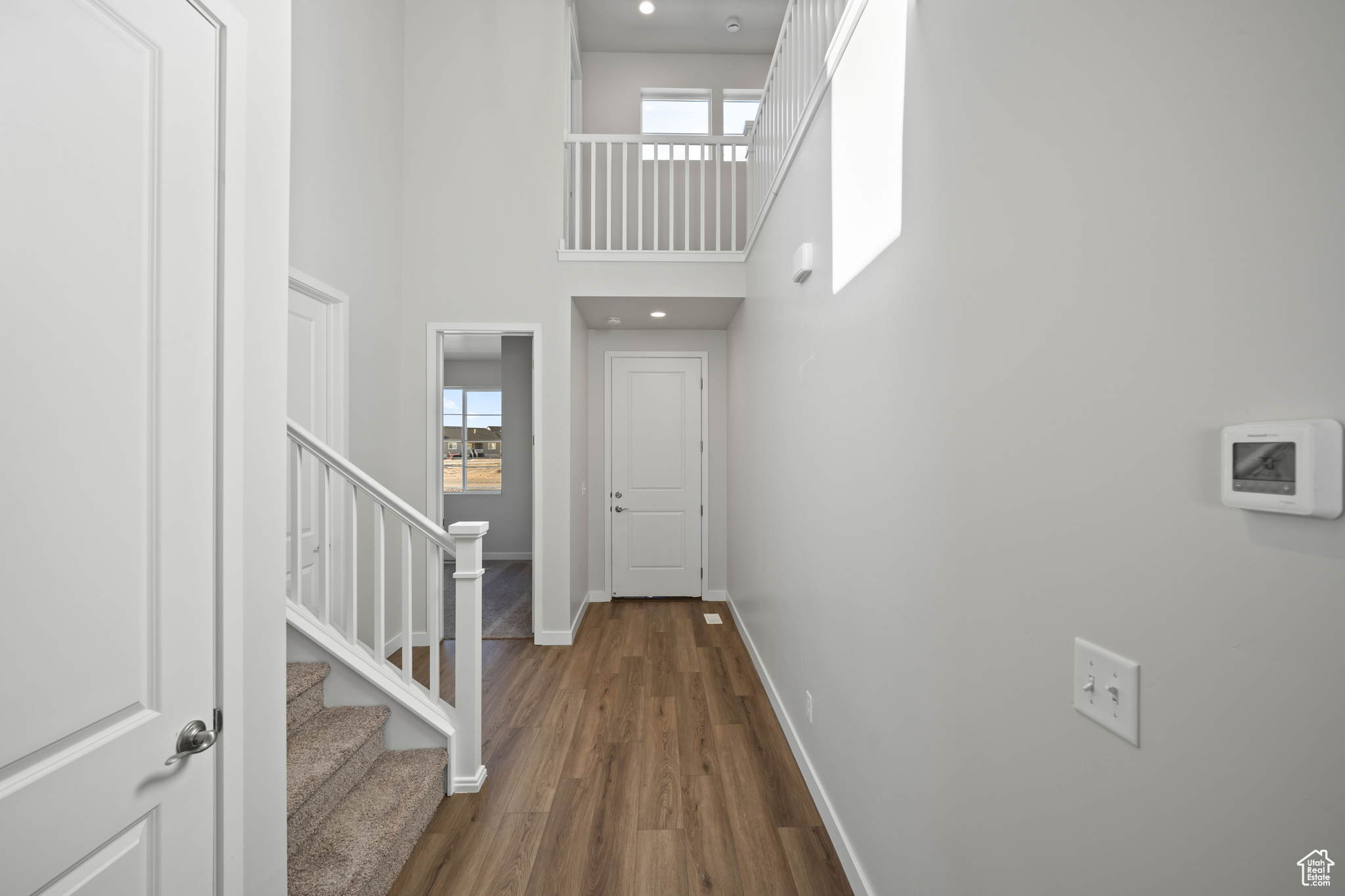 Foyer entrance with hardwood / wood-style flooring, a towering ceiling, and a wealth of natural light