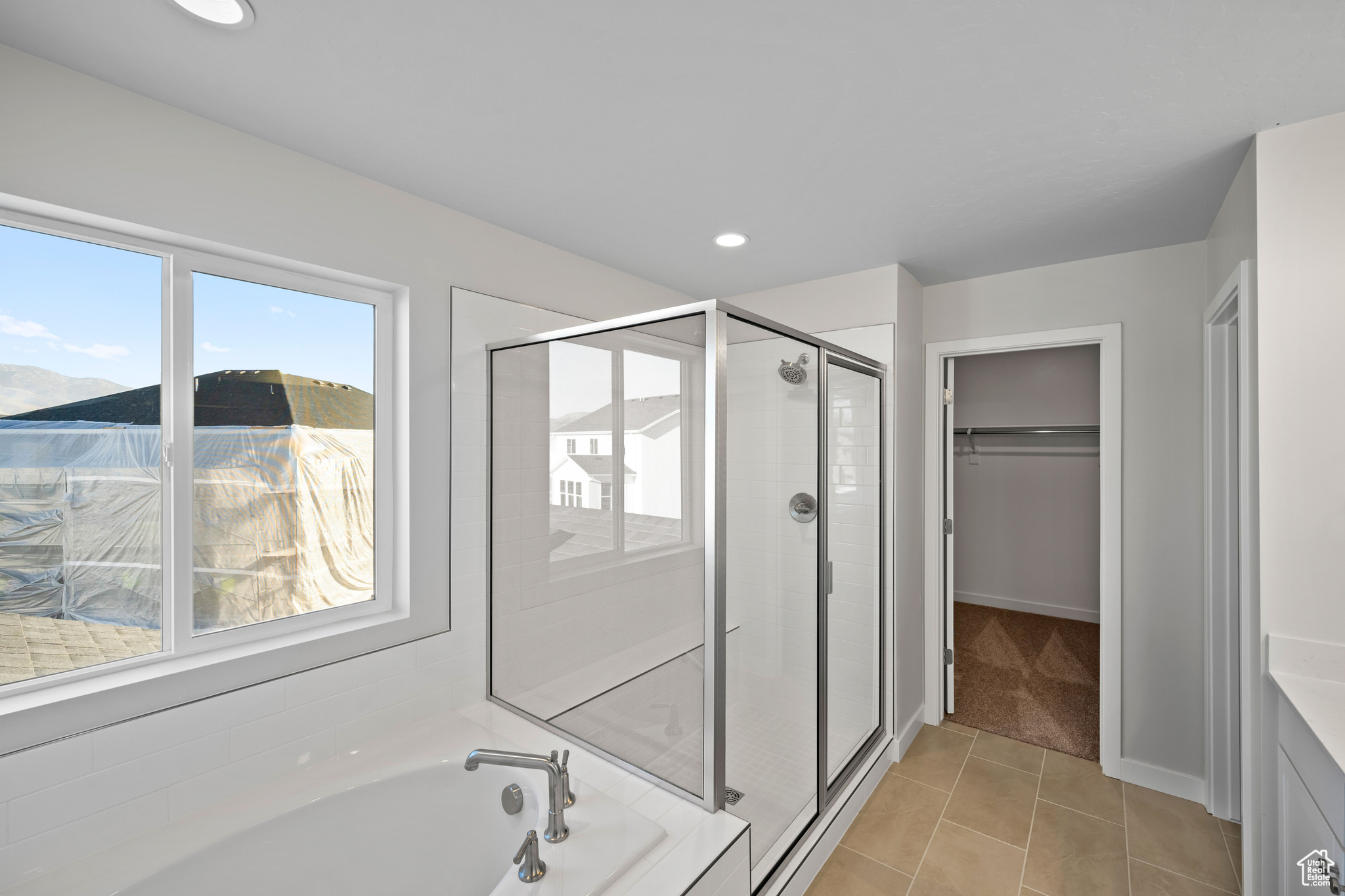 Bathroom with shower with separate bathtub, tile patterned floors, and vanity