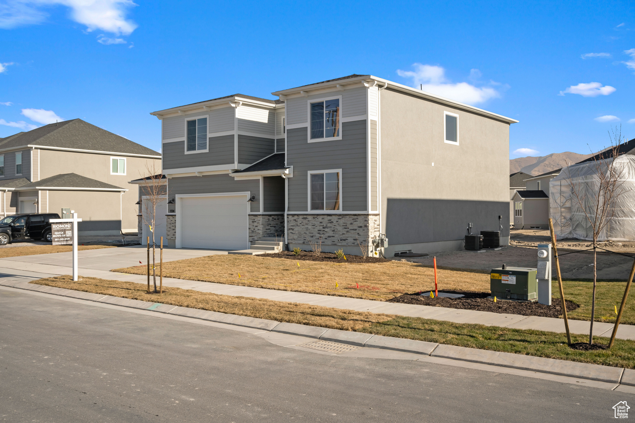 View of front of home featuring a garage and central AC