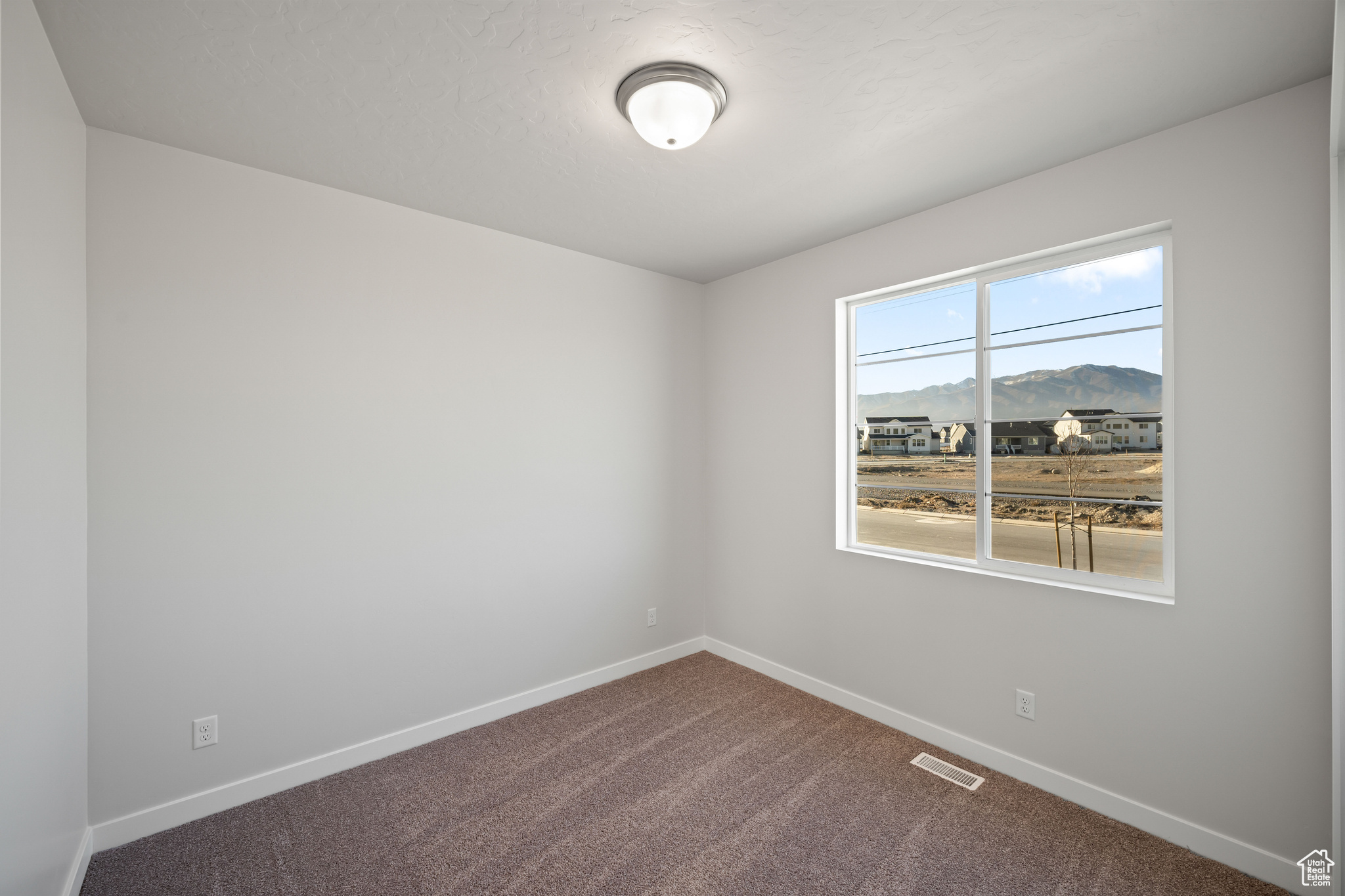 Carpeted empty room featuring a mountain view