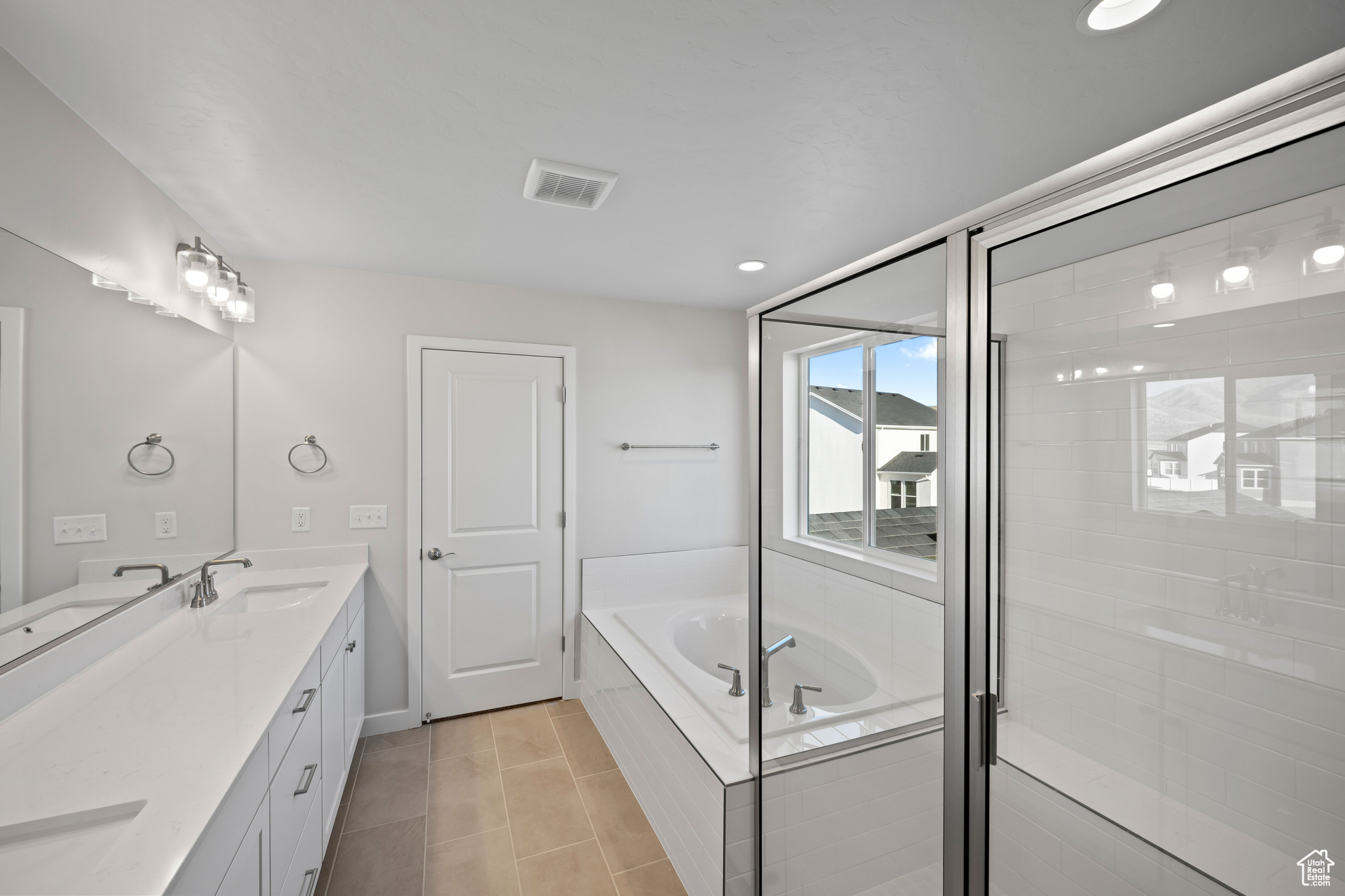 Bathroom with vanity and shower with separate bathtub