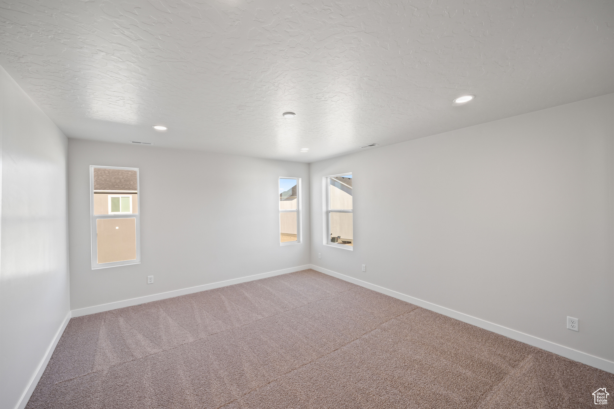 Carpeted spare room with a textured ceiling