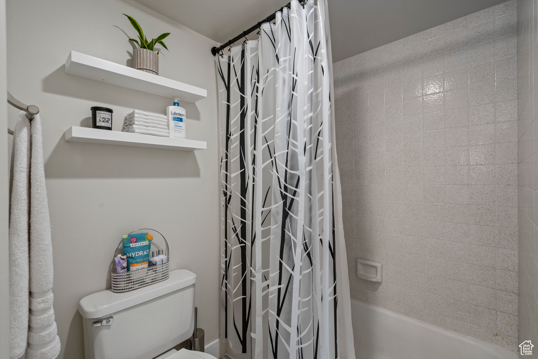 Bathroom featuring shower / bath combination with curtain and toilet