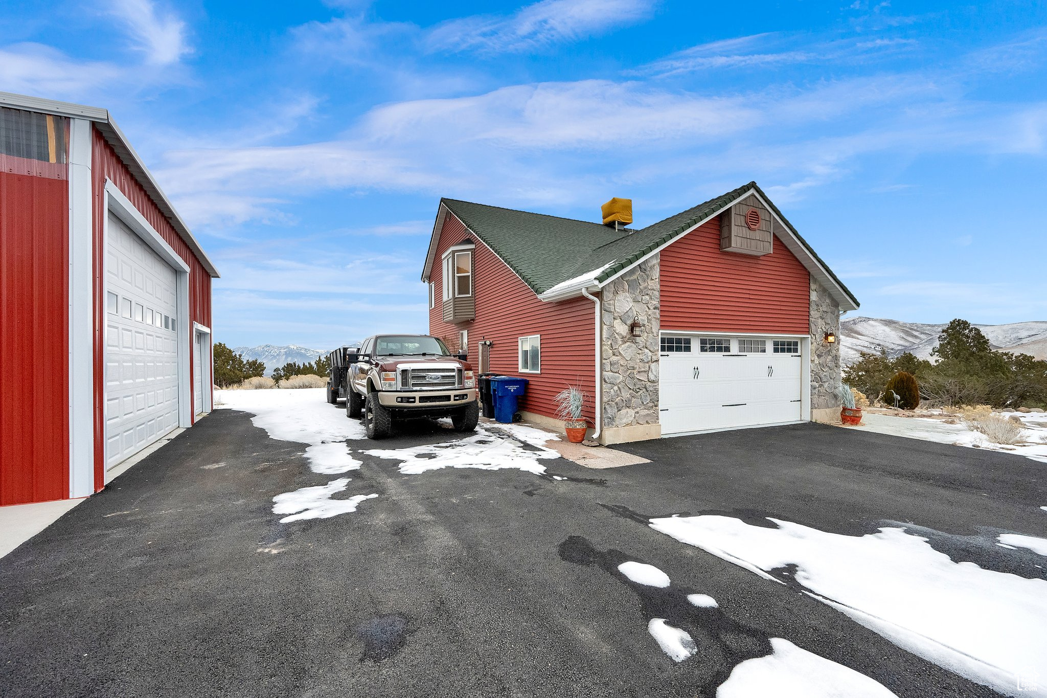 View of snow covered exterior with a garage and a mountain view