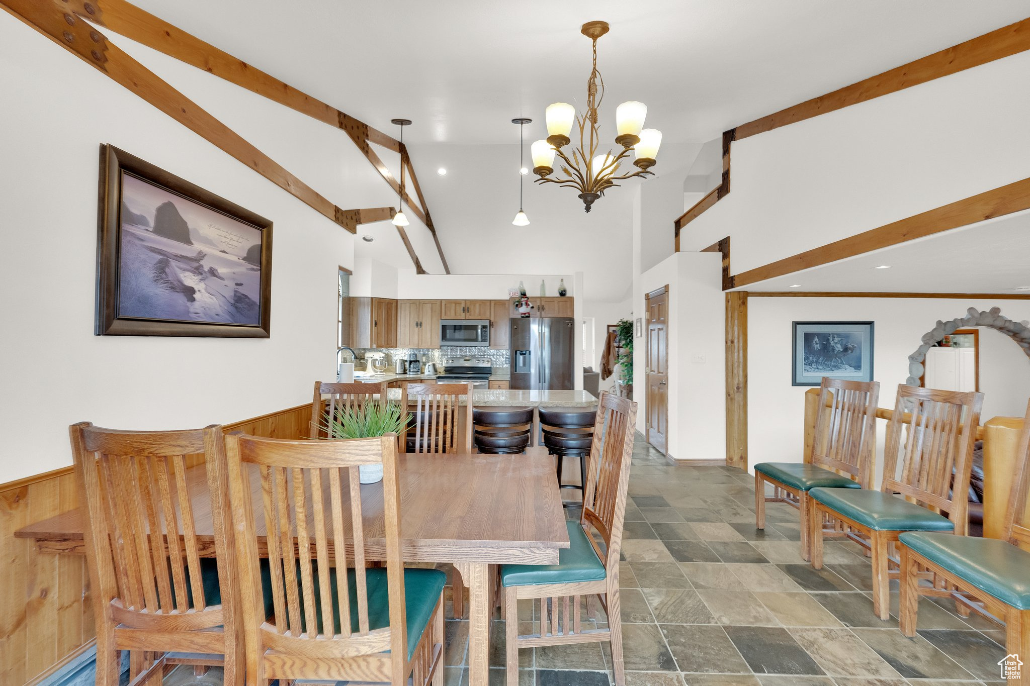 Dining area with high vaulted ceiling and a notable chandelier