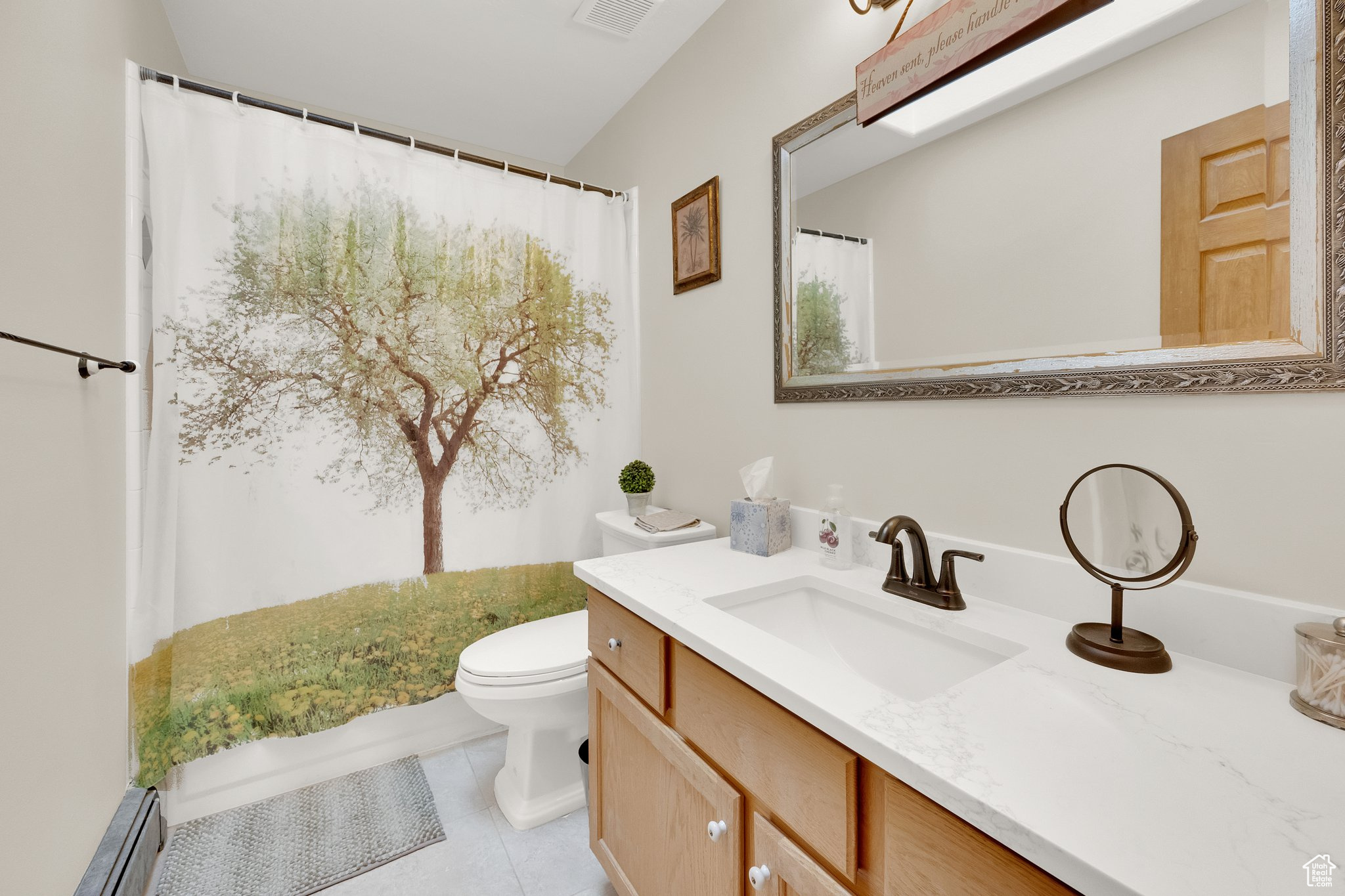 Bathroom with vanity, toilet, tile patterned flooring, and a baseboard heating unit