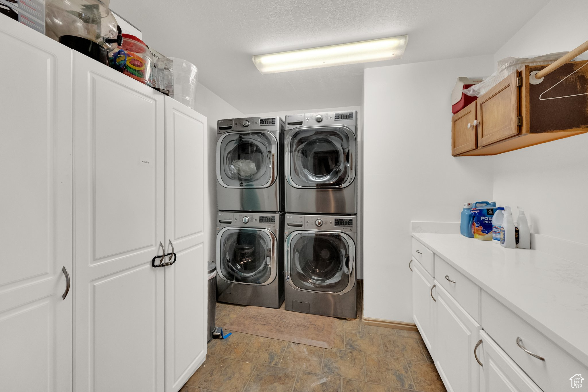 Clothes washing area with stacked washer / drying machine, washing machine and dryer, and cabinets