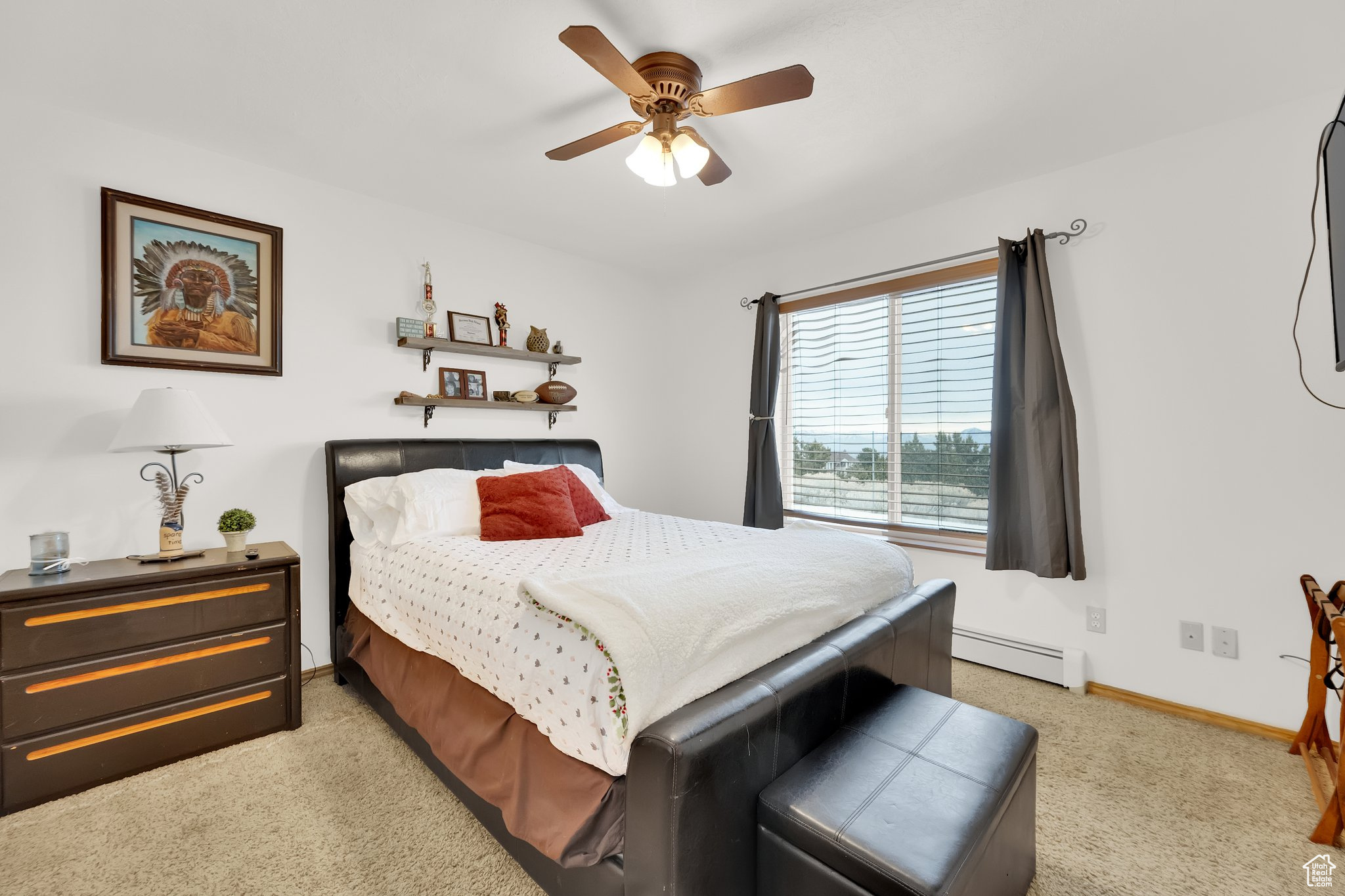 Carpeted bedroom featuring ceiling fan and a baseboard radiator