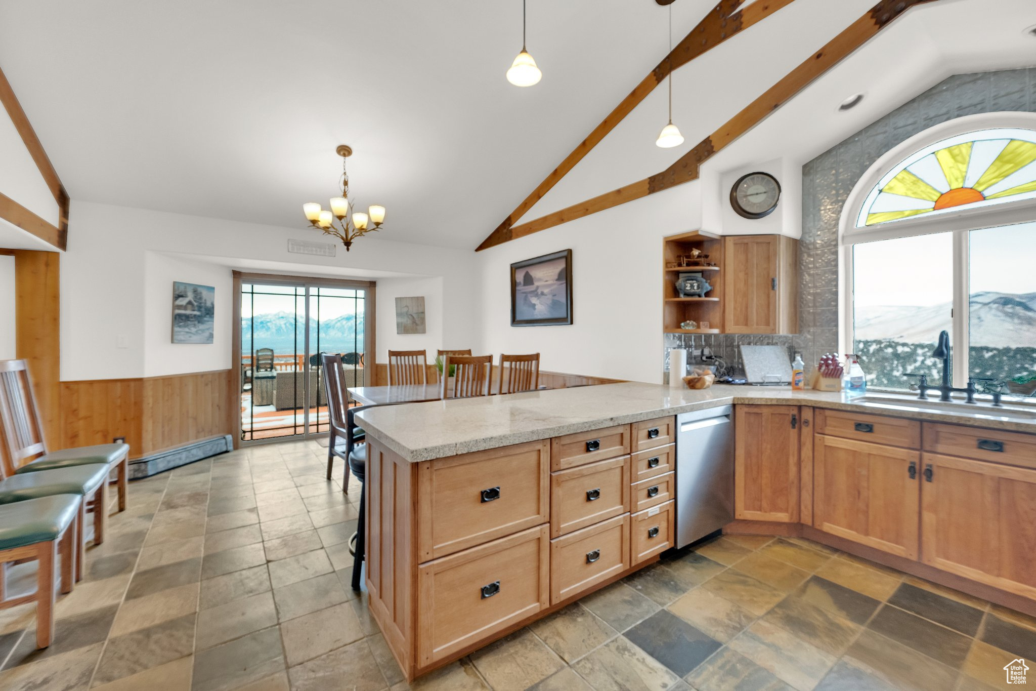 Kitchen featuring dishwasher, sink, hanging light fixtures, kitchen peninsula, and a mountain view