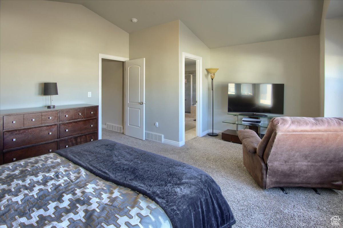 Carpeted bedroom featuring lofted ceiling