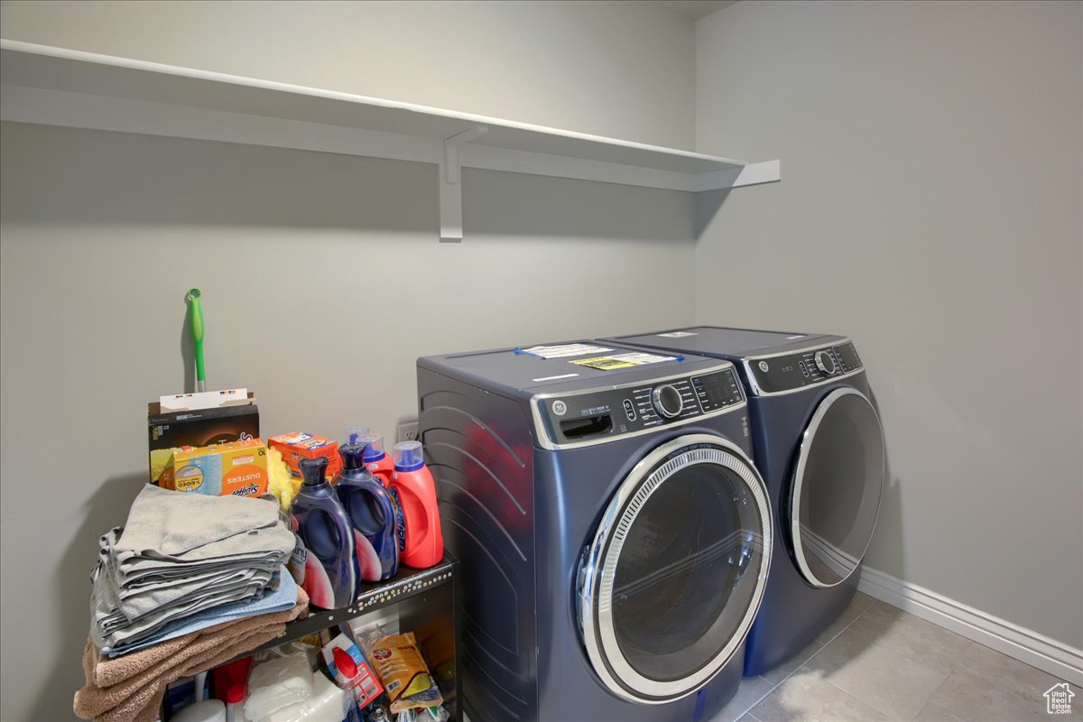 Laundry area with separate washer and dryer and light tile patterned floors