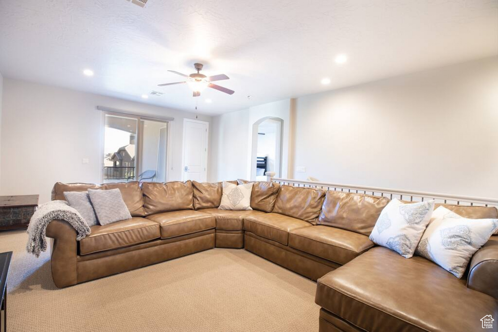 Carpeted living room featuring ceiling fan