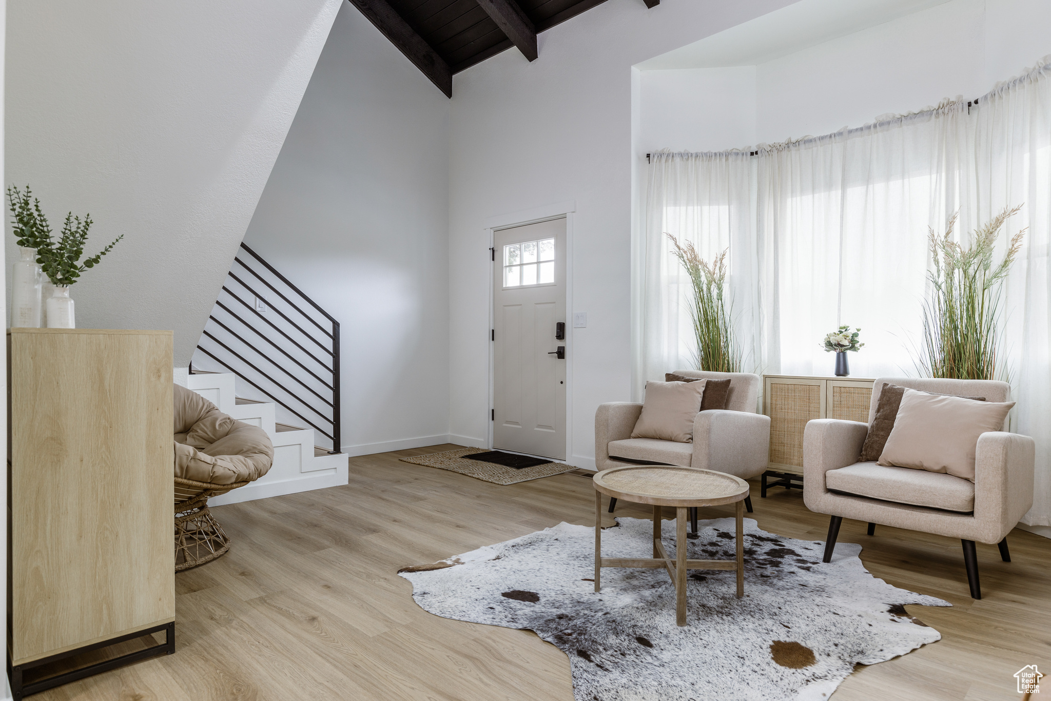 Entryway featuring beamed ceiling, high vaulted ceiling, and light hardwood / wood-style flooring