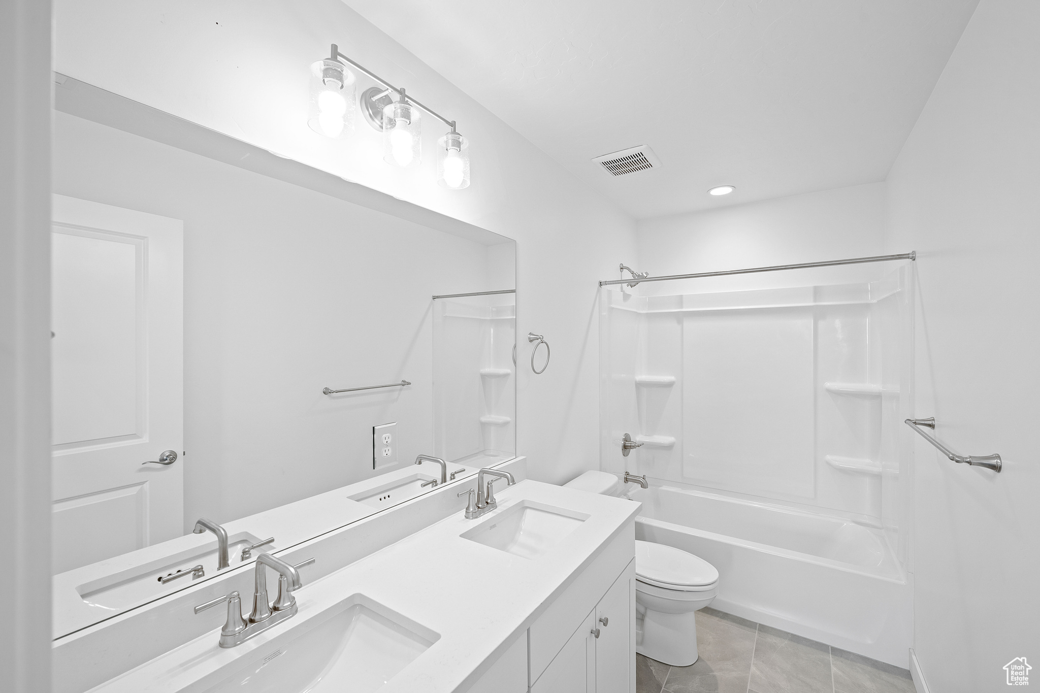 Full bathroom featuring bathtub / shower combination, vanity, tile patterned flooring, and toilet