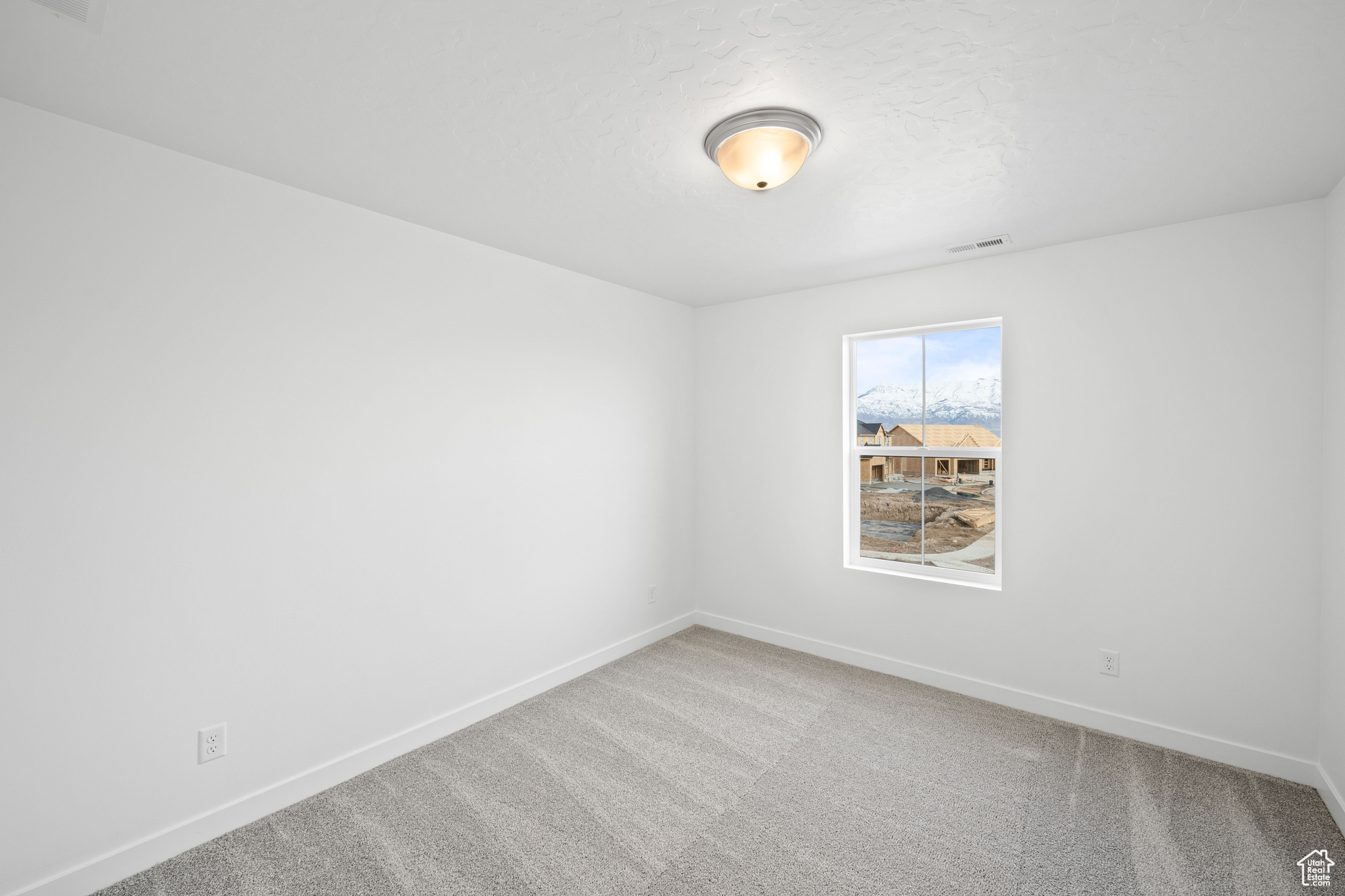 Carpeted spare room with a textured ceiling