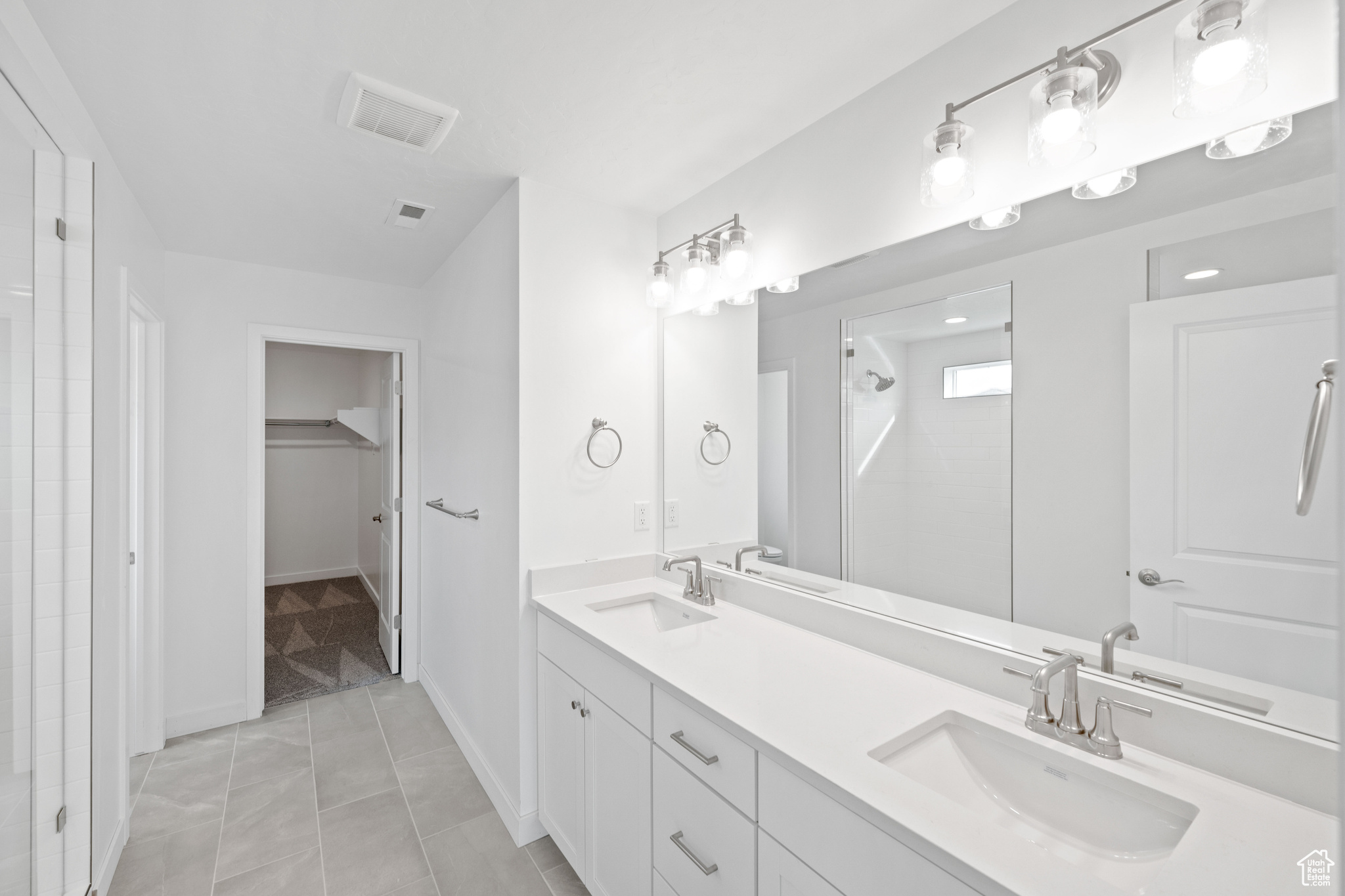 Bathroom featuring vanity, tile patterned floors, and walk in shower