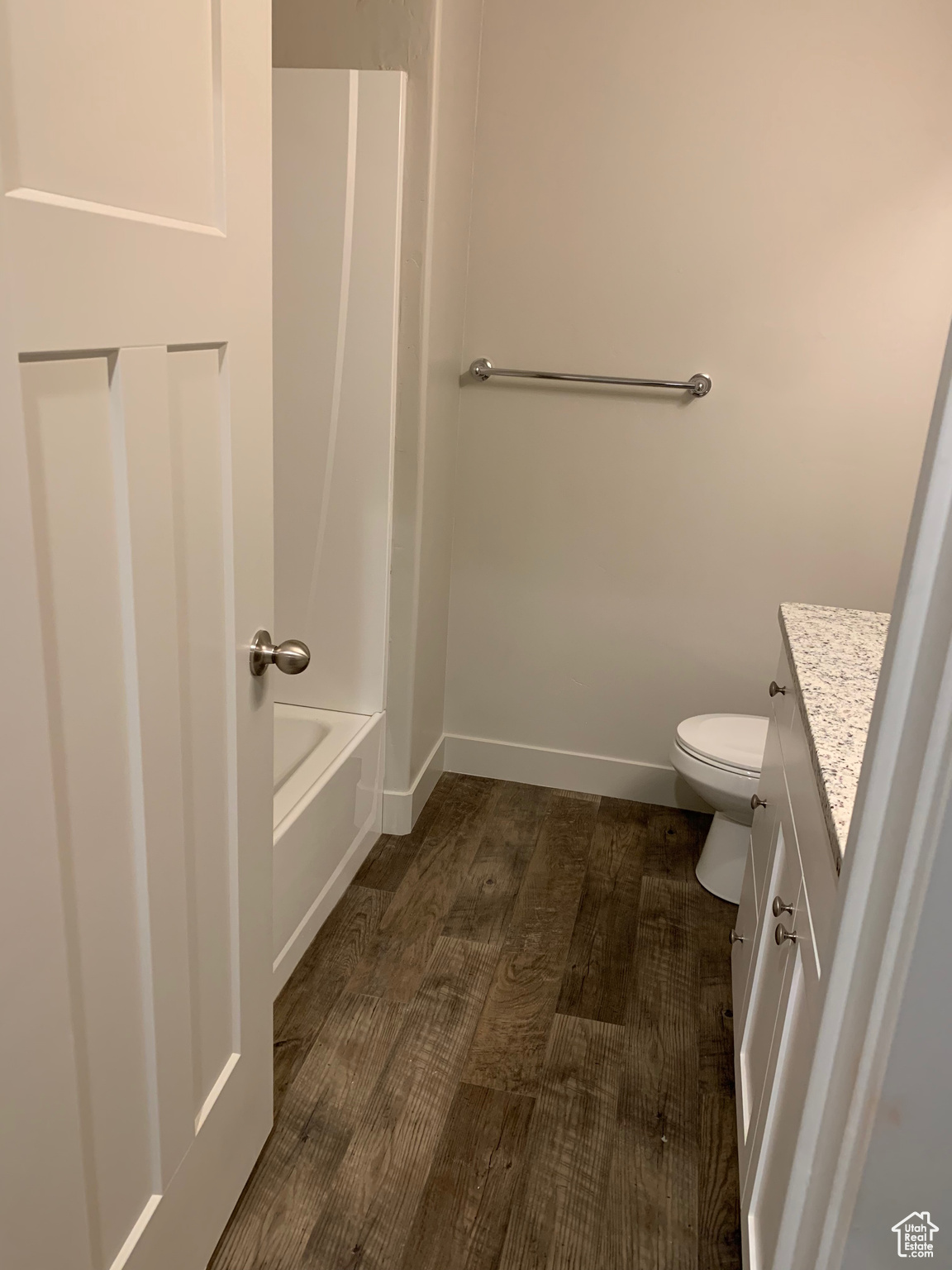 Full bathroom with wood-type flooring, toilet, shower / bath combination, and vanity