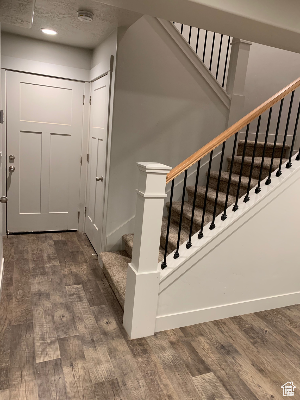 Stairway featuring wood-type flooring and a textured ceiling