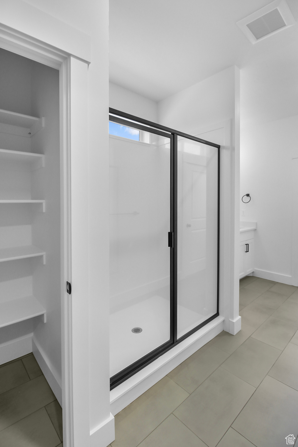 Bathroom with an enclosed shower and linen closet