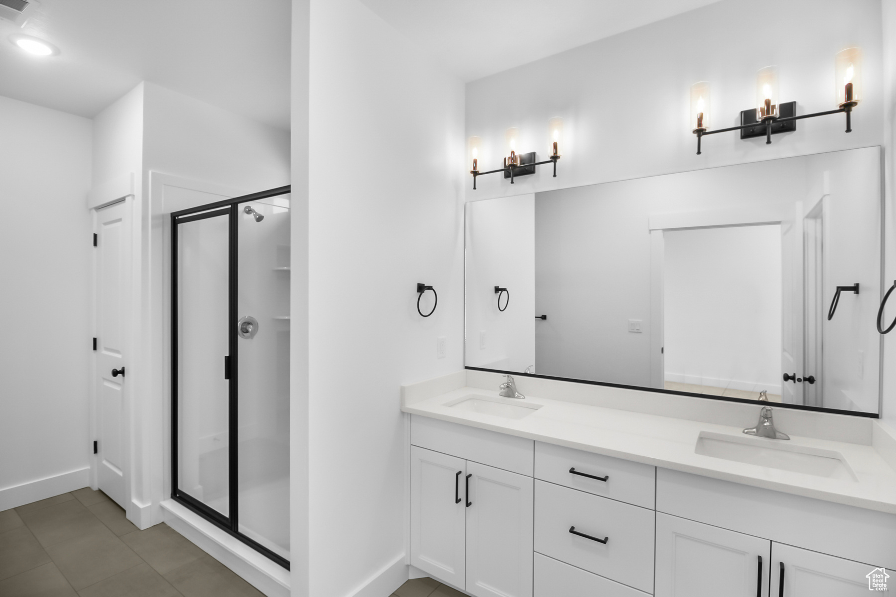 Bathroom with double sink vanity, walk in shower, and linen closet