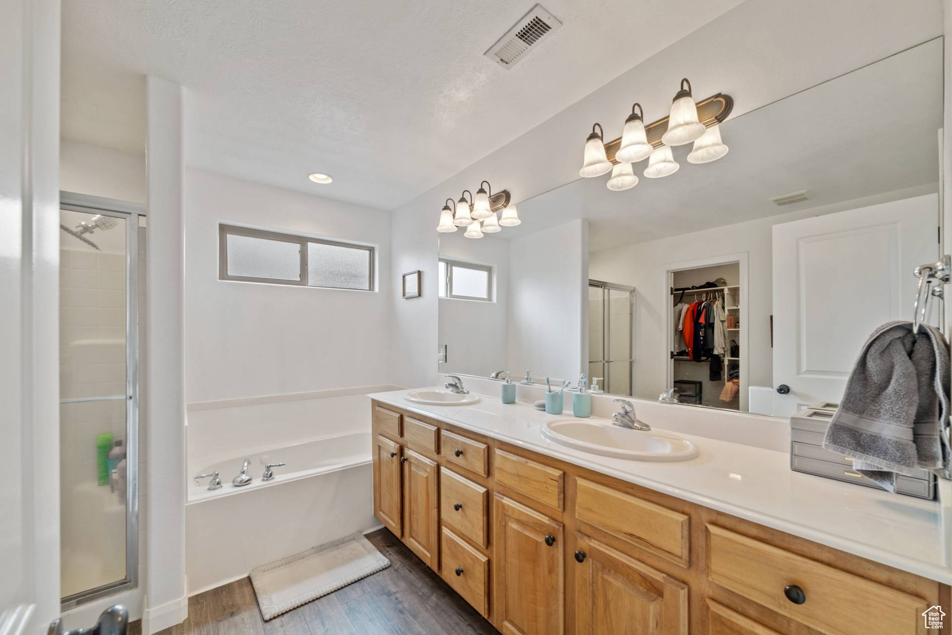 Bathroom featuring vanity, hardwood / wood-style floors, and separate shower and tub