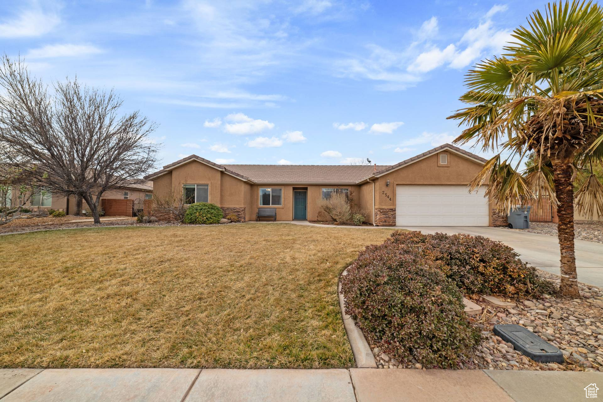 Ranch-style home with a garage and a front lawn