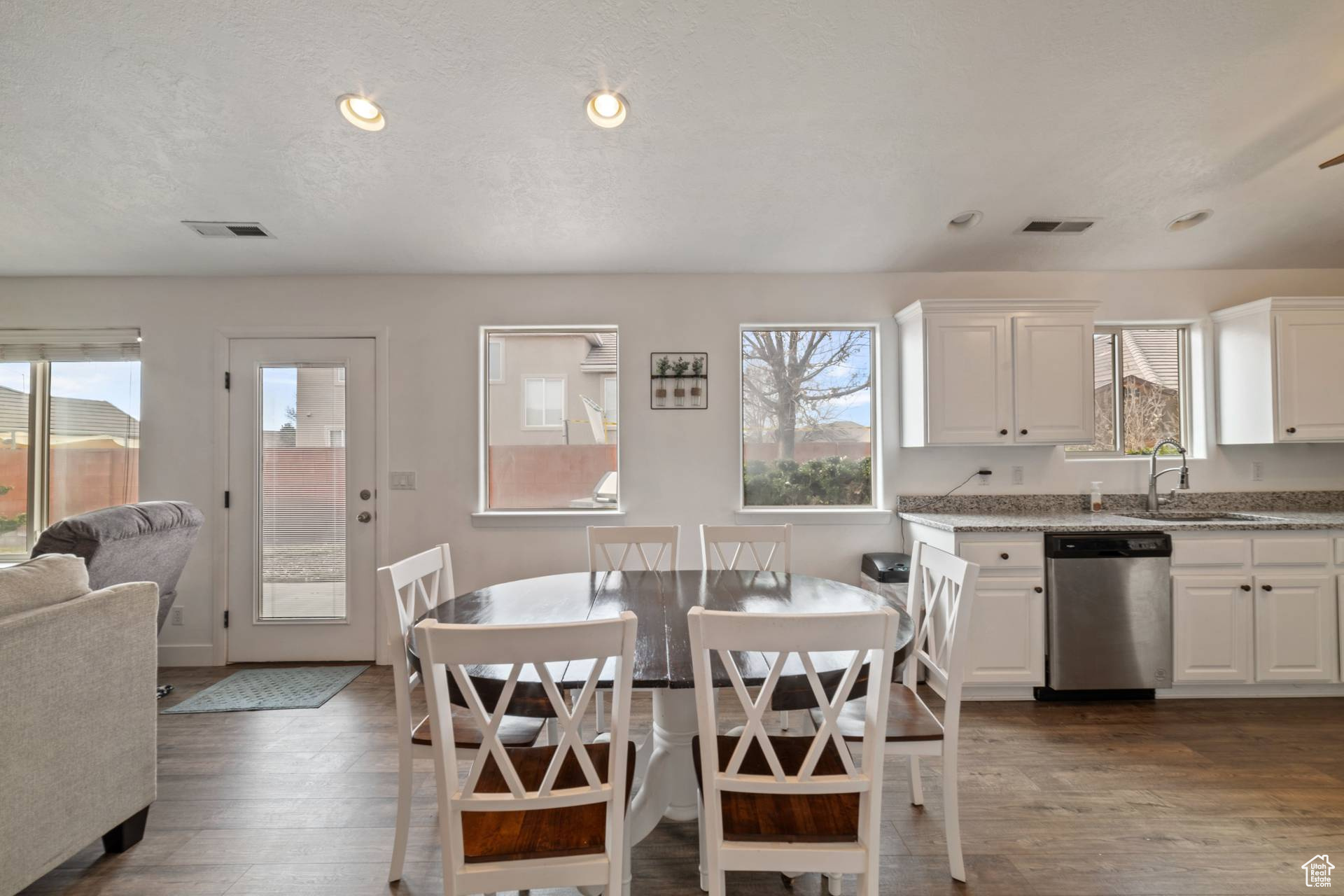 Dining area featuring sink, dark wood-type flooring, and a textured ceiling