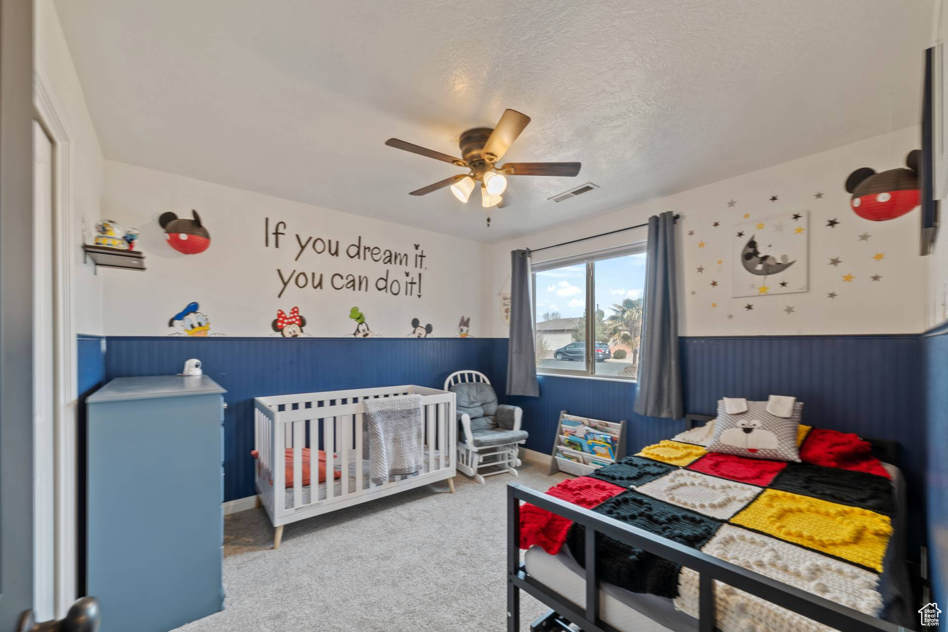 Carpeted bedroom with a textured ceiling and ceiling fan