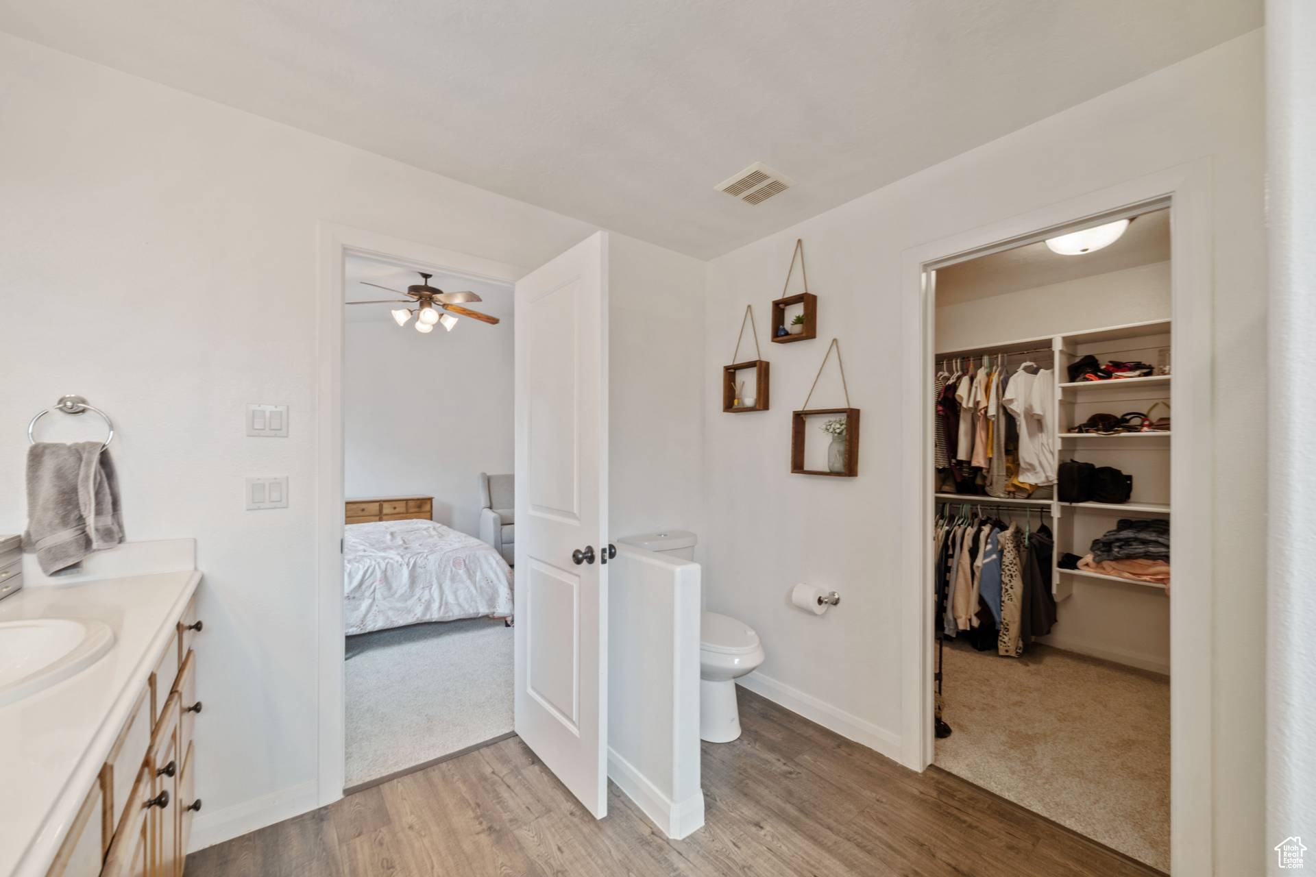 Bathroom featuring vanity, ceiling fan, wood-type flooring, and toilet