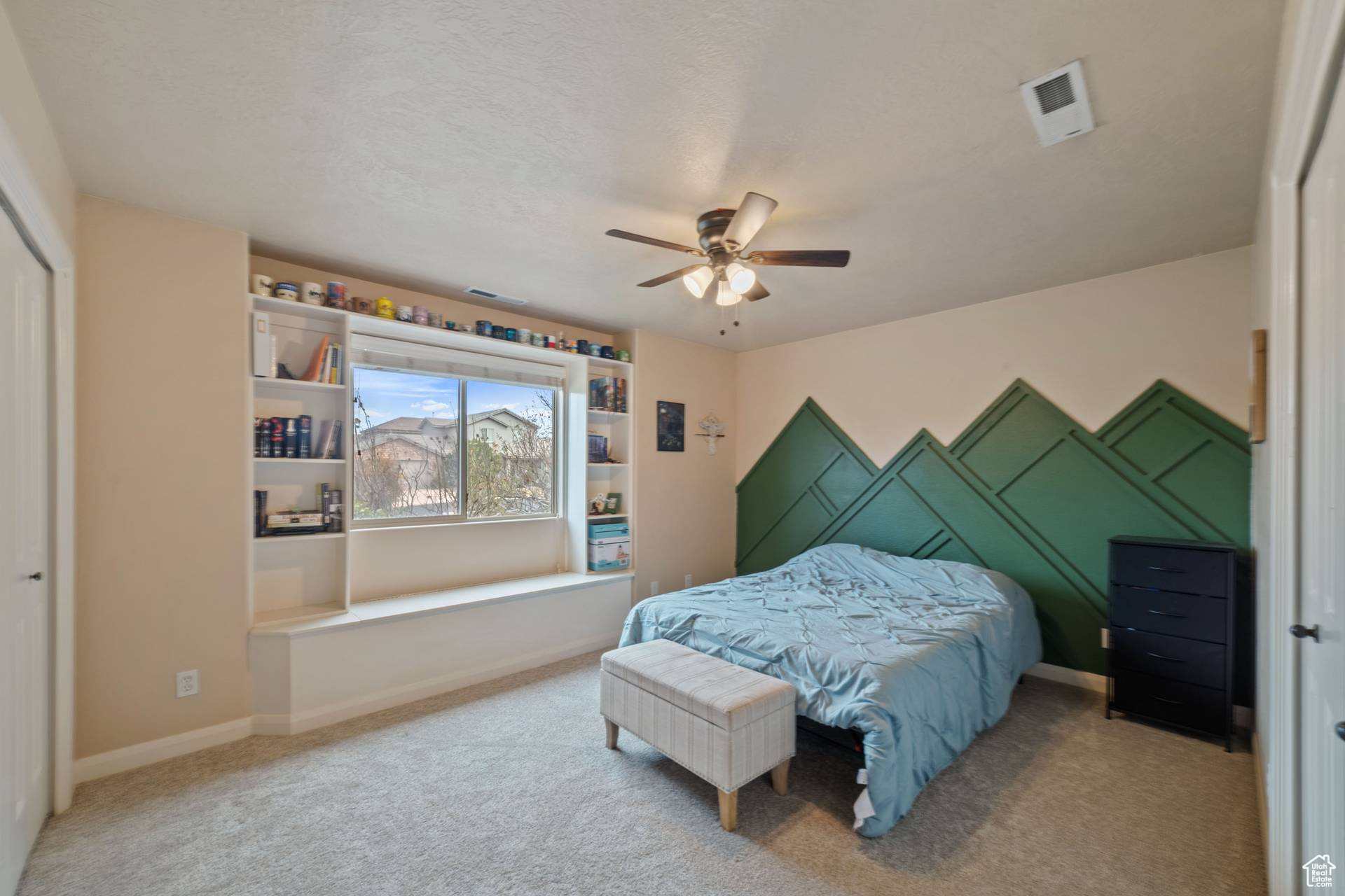 Carpeted bedroom with a closet and ceiling fan