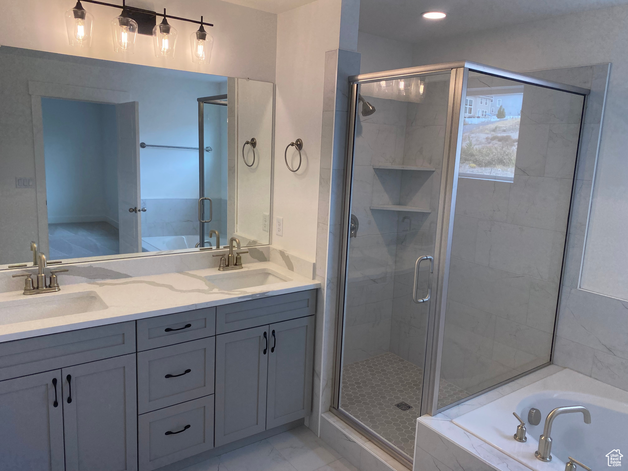 Bathroom featuring vanity and shower with separate bathtub