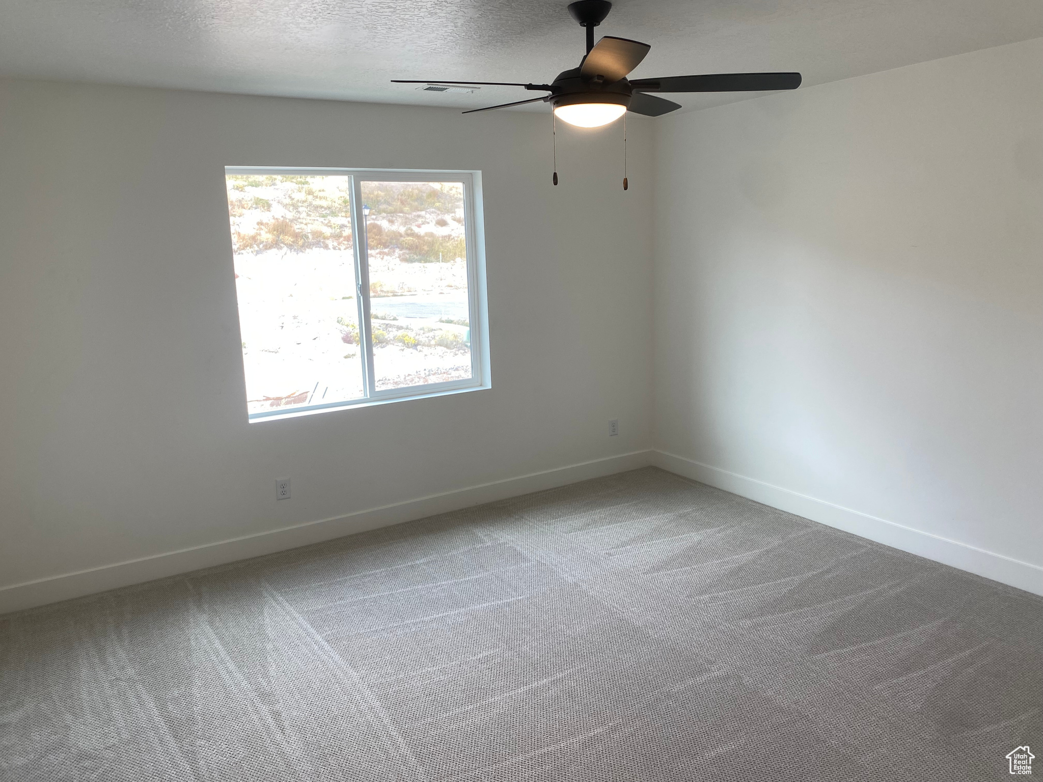 Bedroom with ceiling fan, and light colored carpet