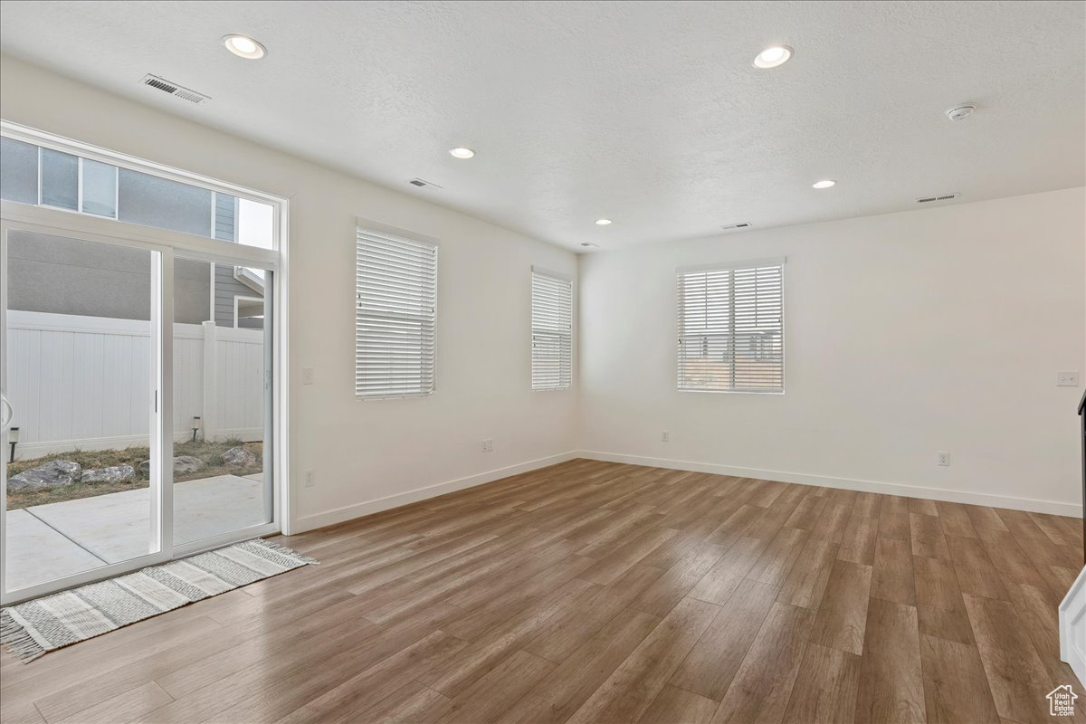 Unfurnished room with hardwood / wood-style flooring and a textured ceiling