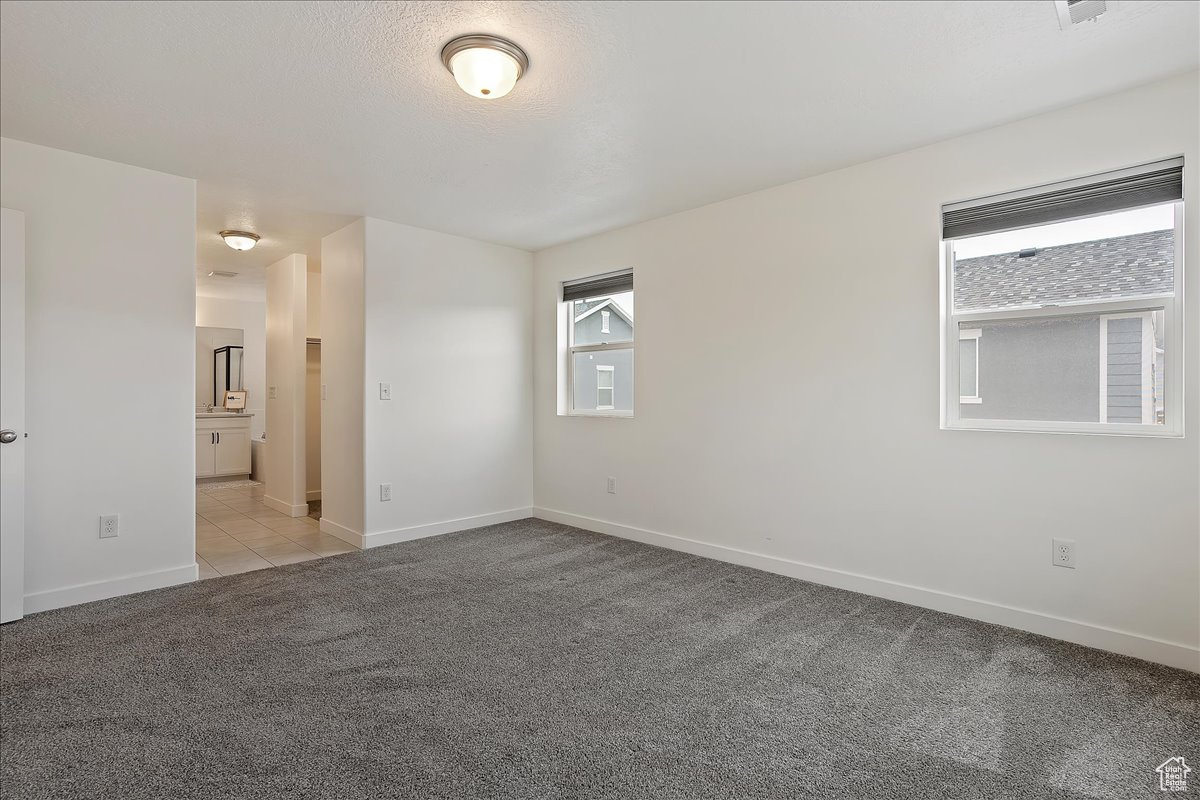 Carpeted spare room featuring a textured ceiling