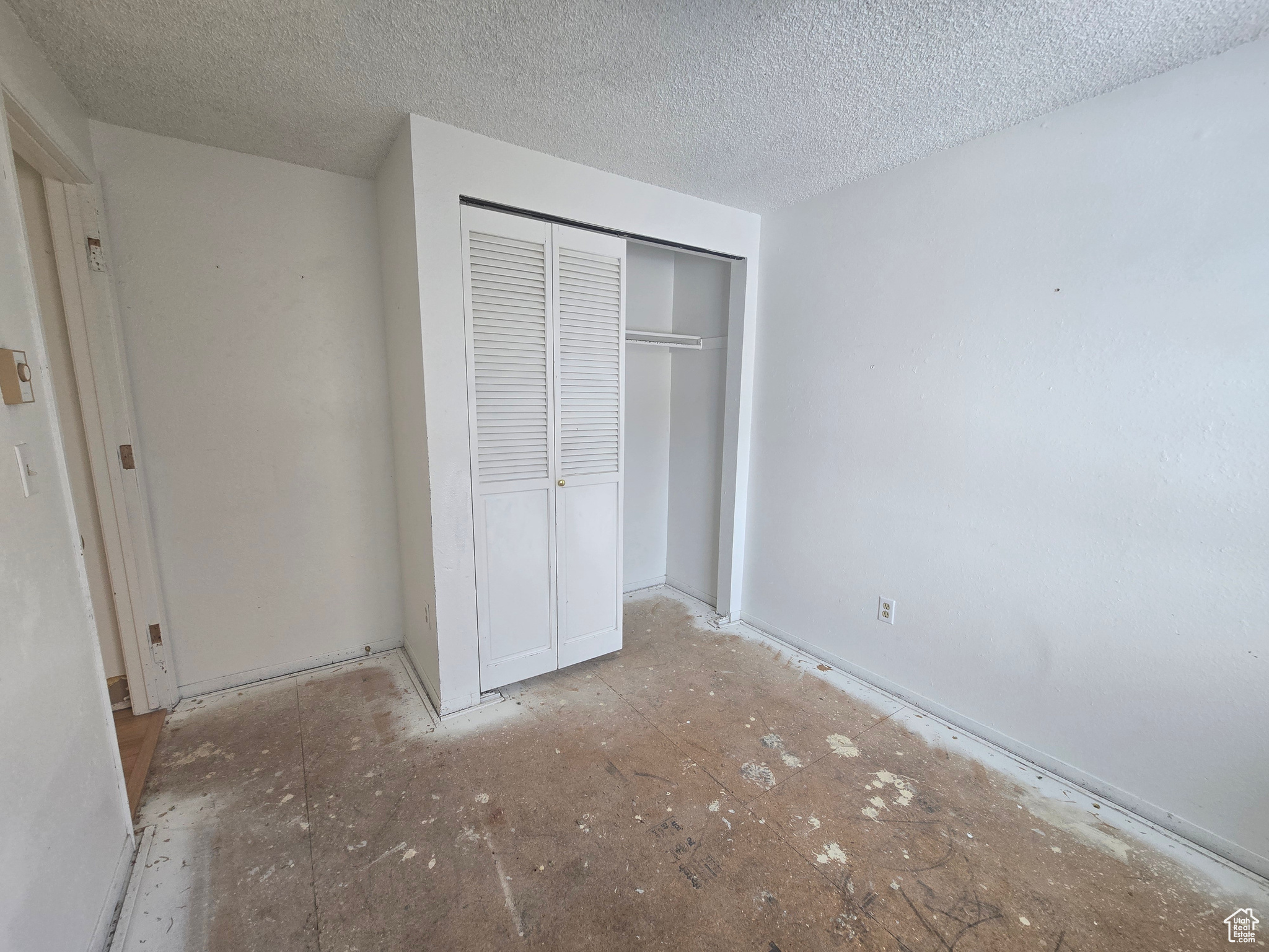 Unfurnished bedroom featuring a closet and a textured ceiling