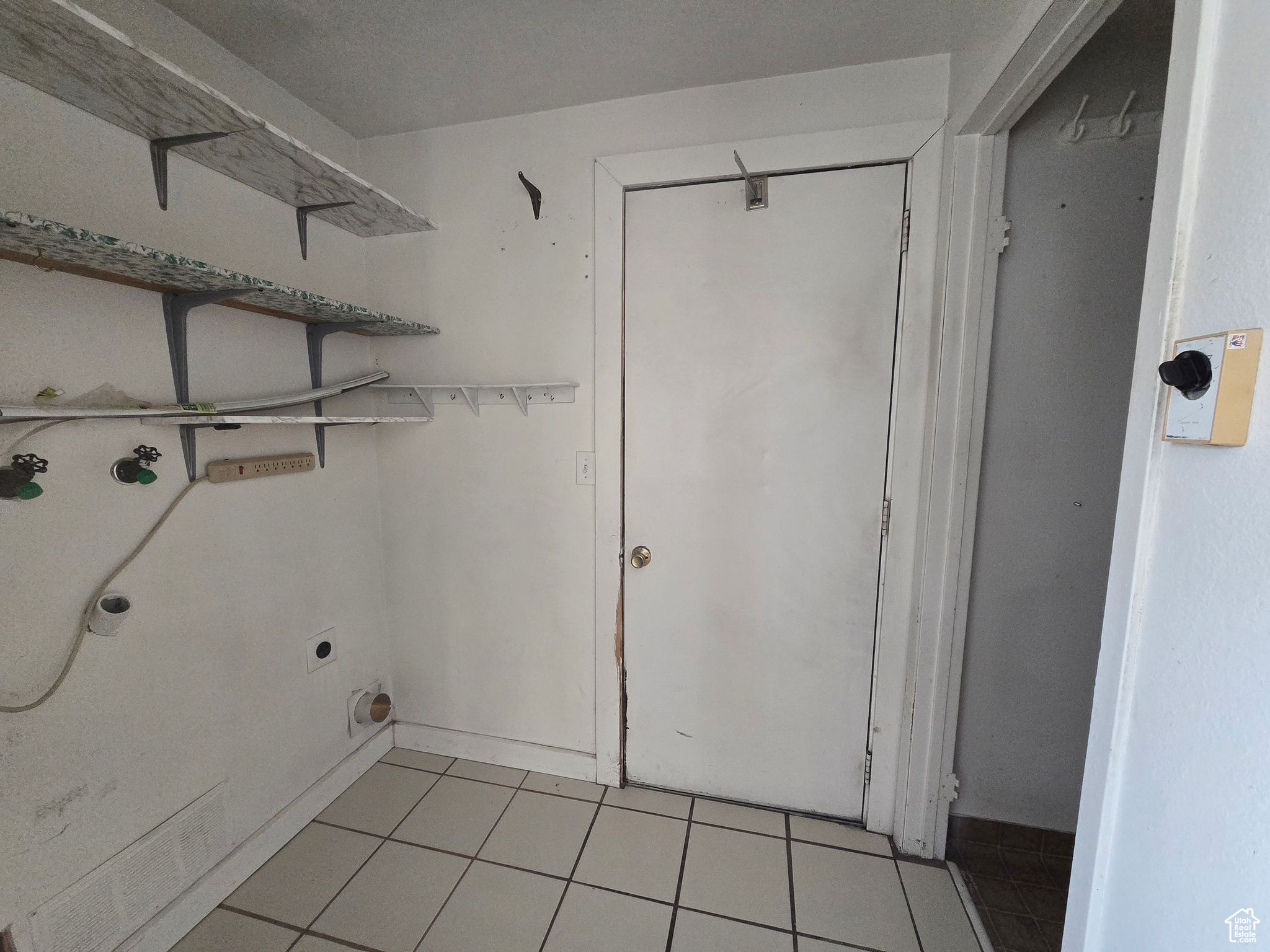 Washroom with washer hookup, hookup for an electric dryer, and light tile patterned floors