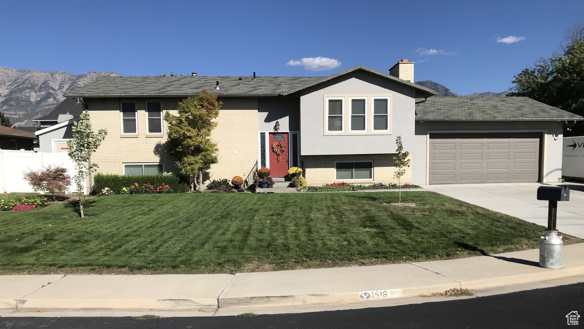 View of front of house featuring a garage, a mountain view, and a front yard