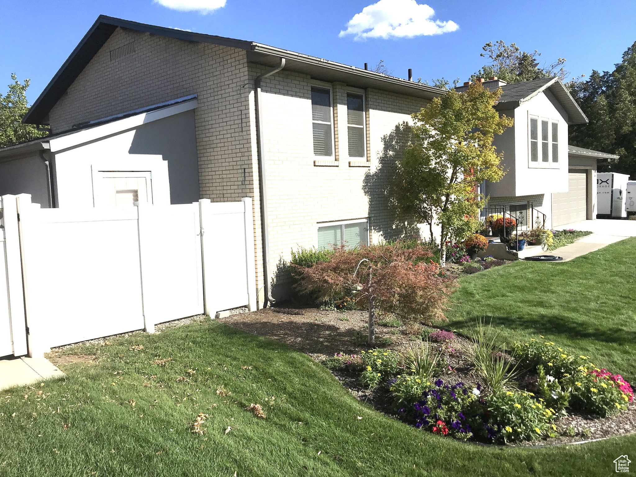 View of property exterior featuring a garage and a lawn