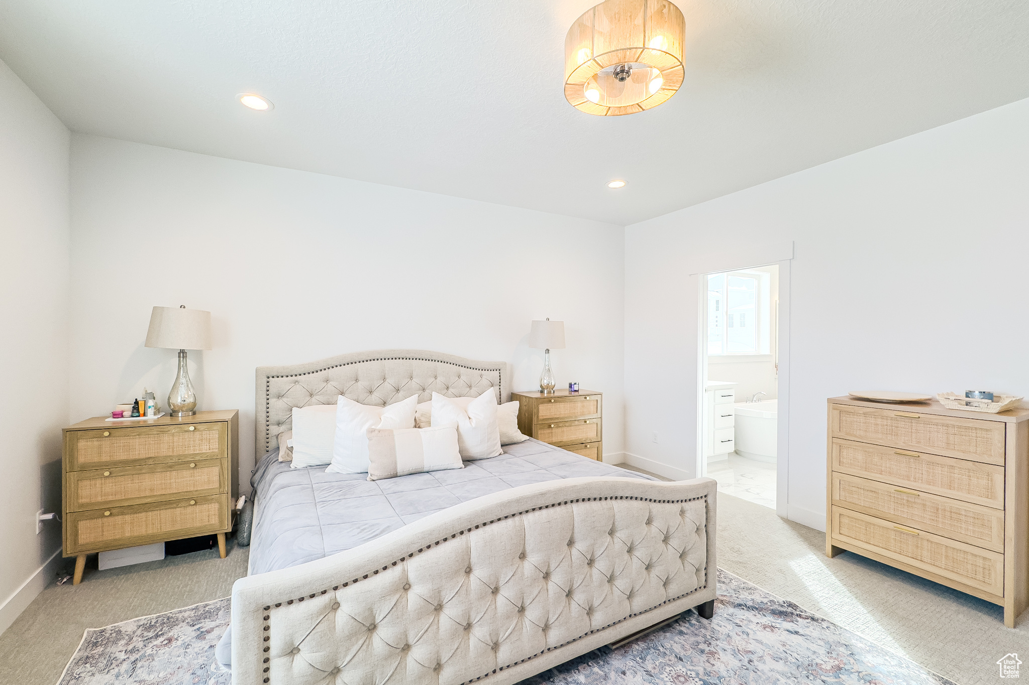 Bedroom featuring light carpet and connected bathroom