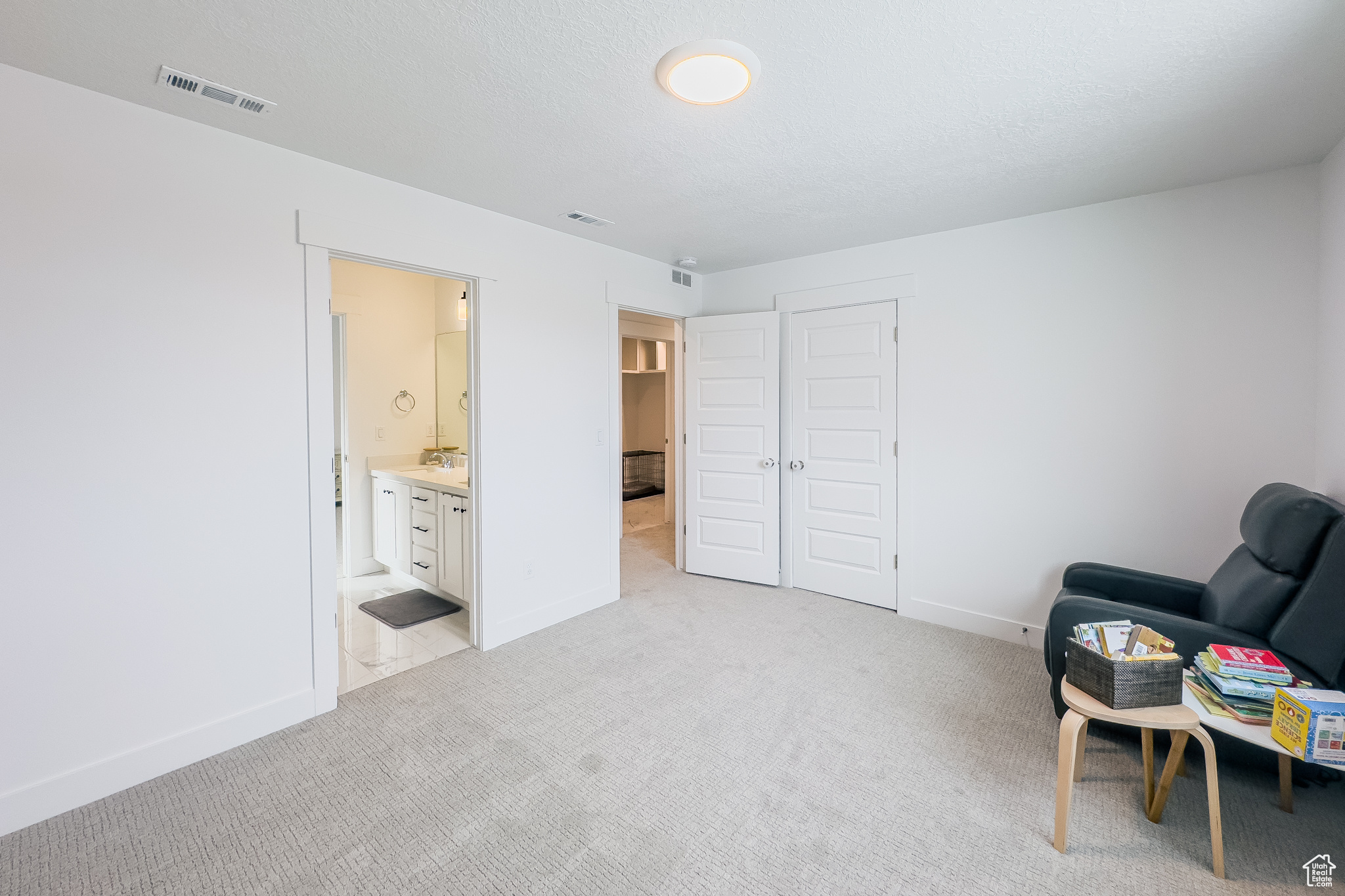 Sitting room with sink, light carpet, and a textured ceiling