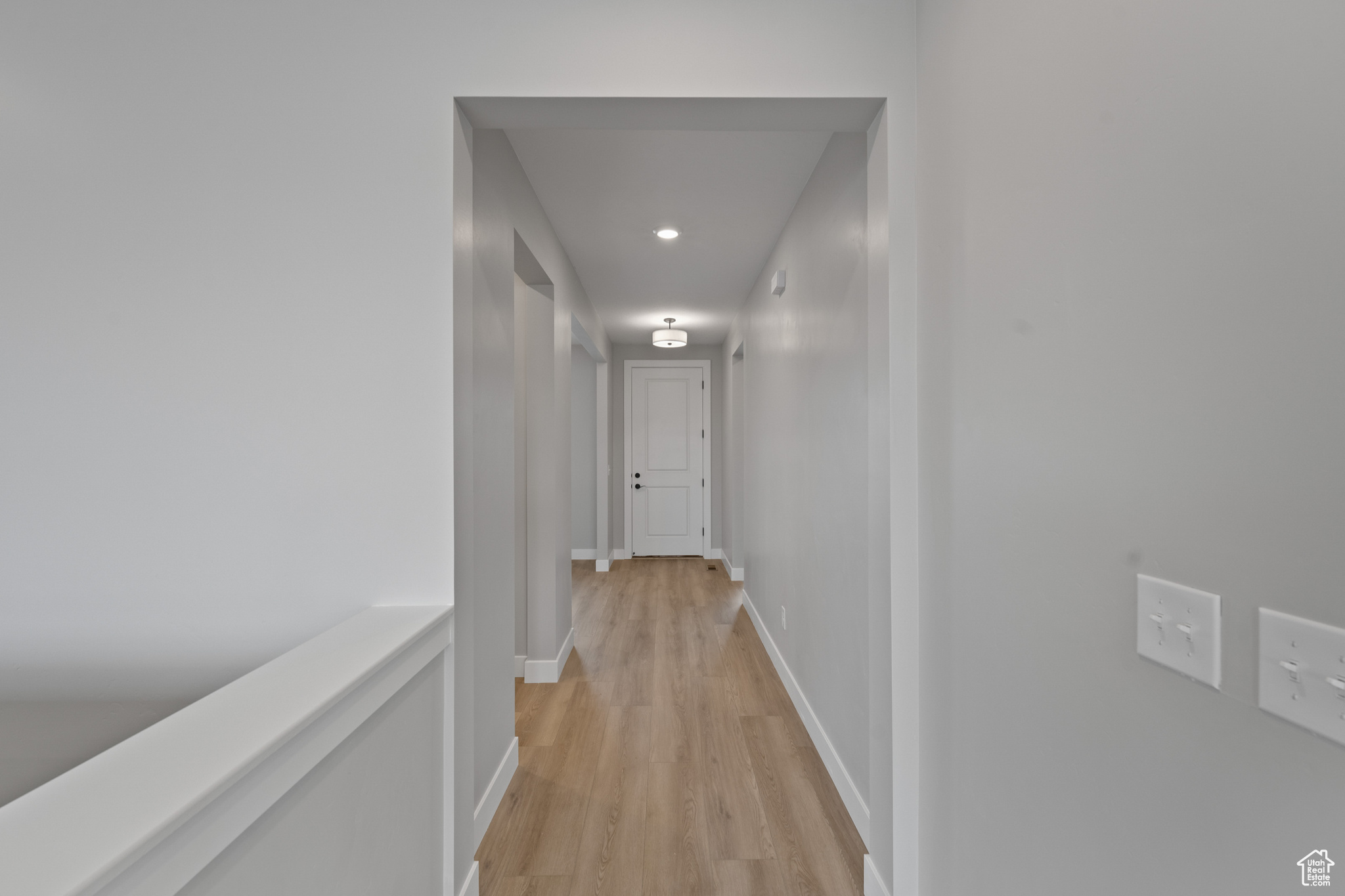 Corridor with light hardwood / wood-style flooring