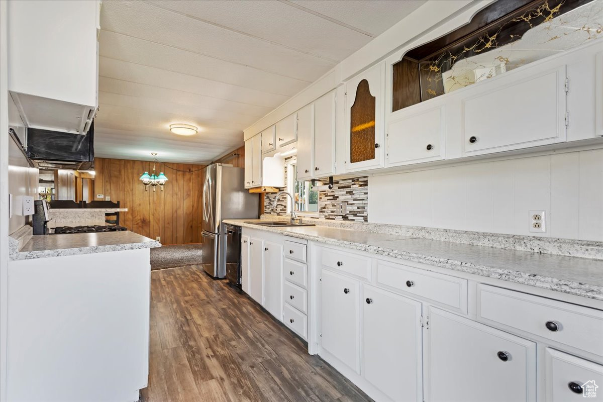 Kitchen featuring pendant lighting, dishwasher, white cabinetry, sink, and dark wood-type flooring