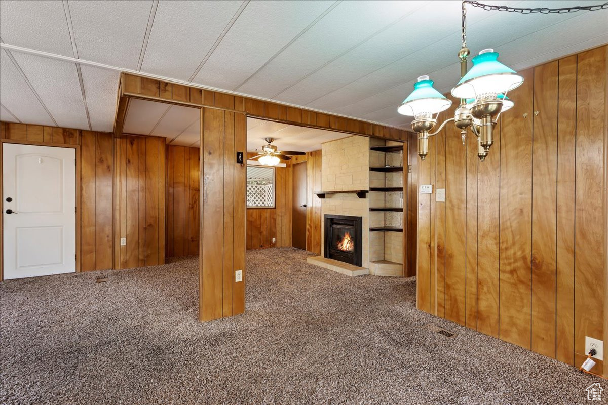 Unfurnished living room featuring carpet floors and wooden walls