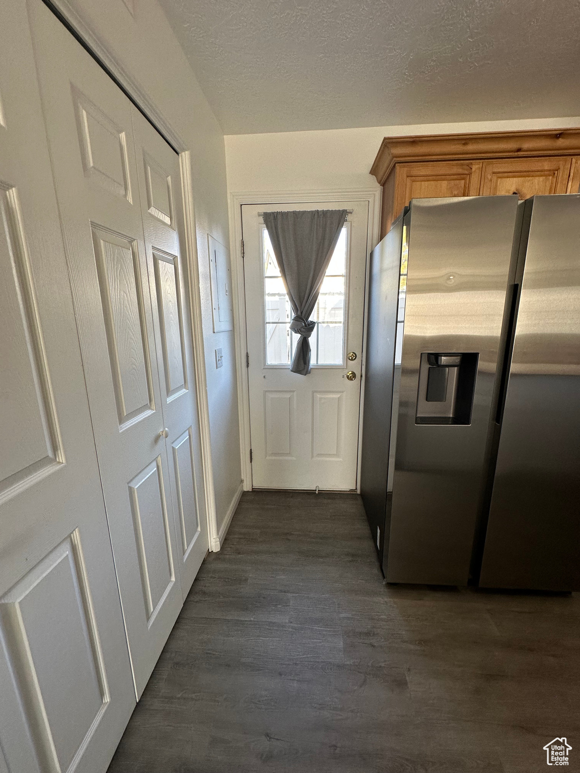 Doorway with dark hardwood / wood-style flooring and a textured ceiling