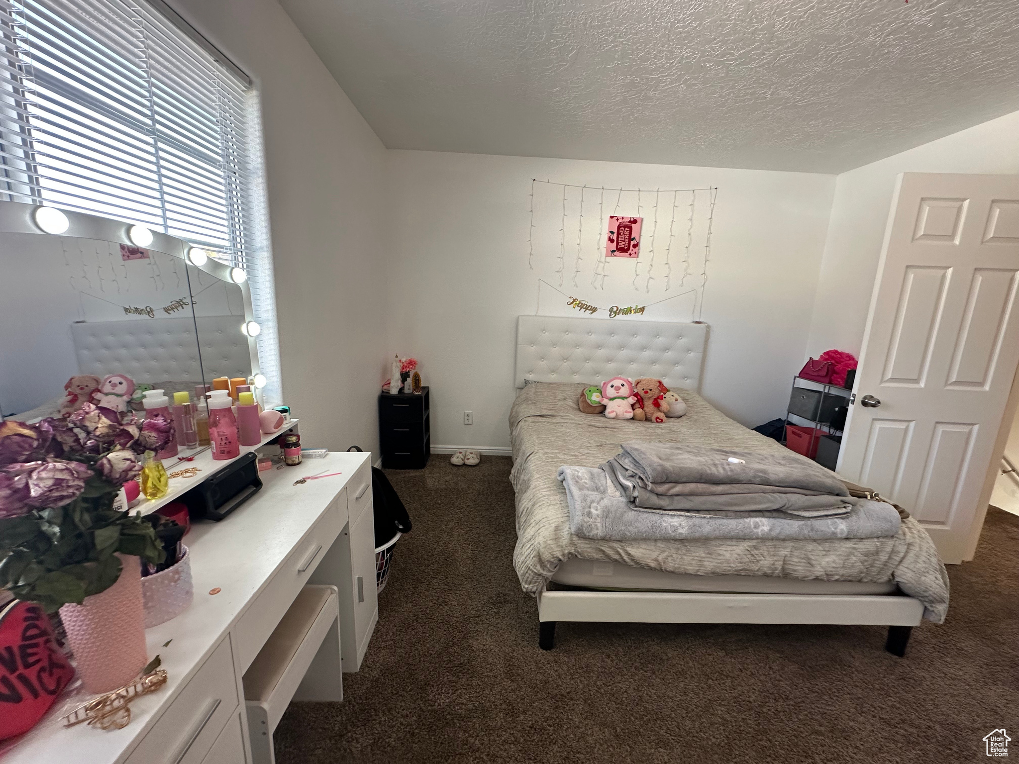 Carpeted bedroom with a textured ceiling