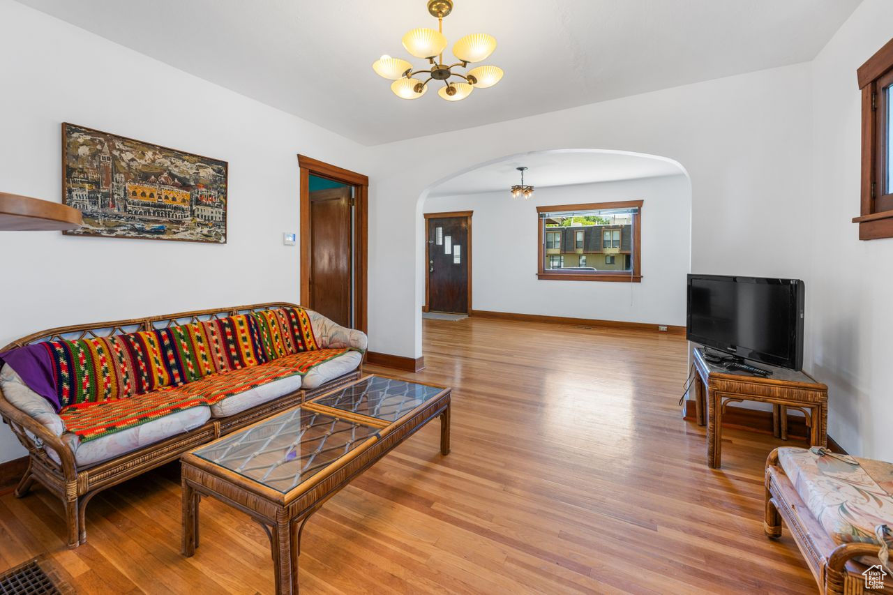 Living room with a notable chandelier and light wood-type flooring