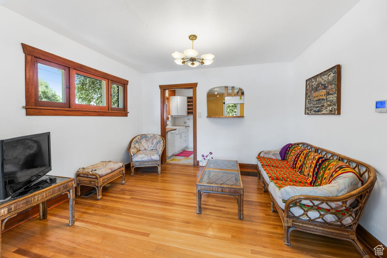 Living area with an inviting chandelier and light hardwood / wood-style flooring